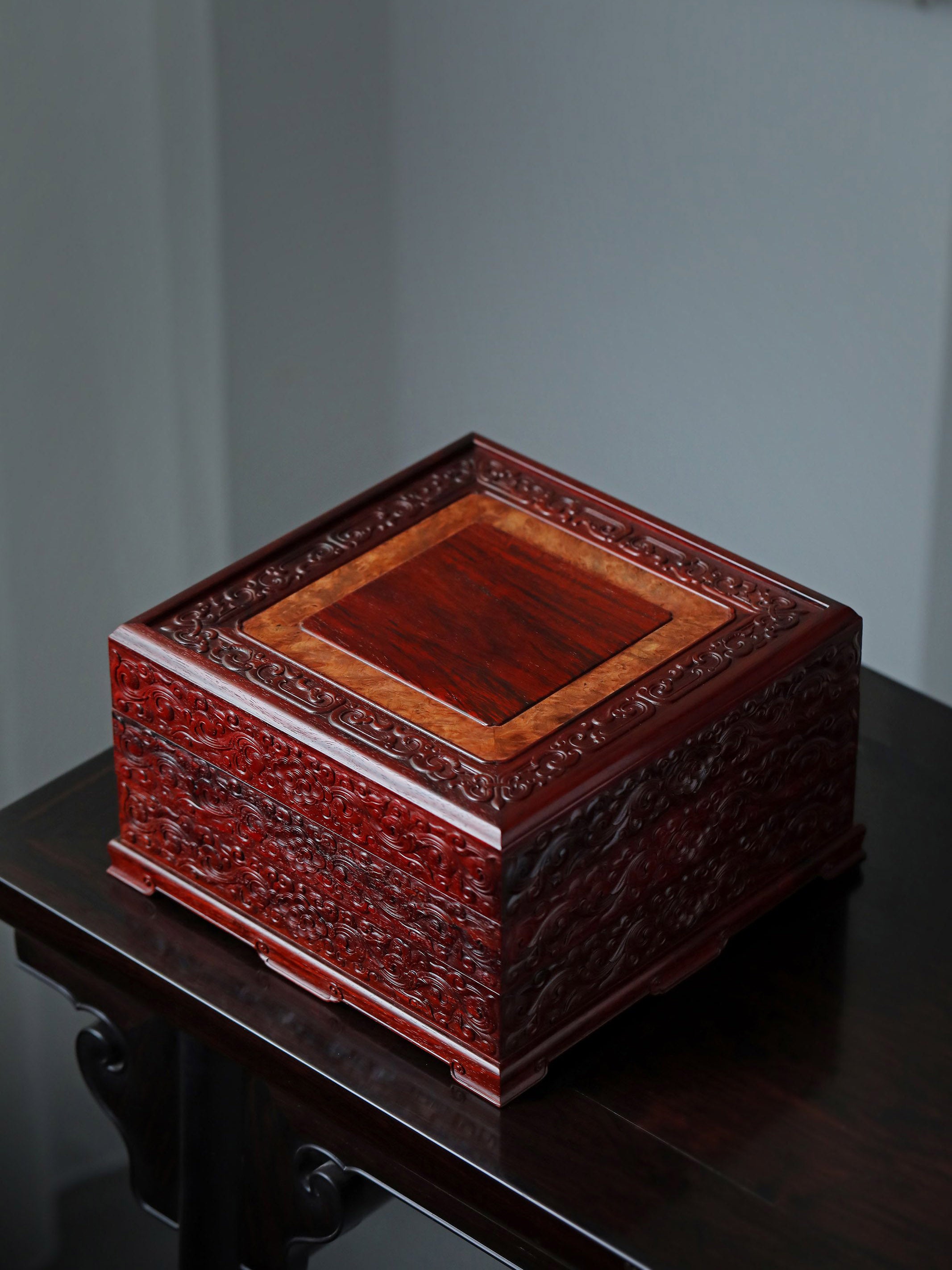 Small-leaf sandalwood tea box with auspicious cloud and scroll patterns, three-tiered lid and four corners.