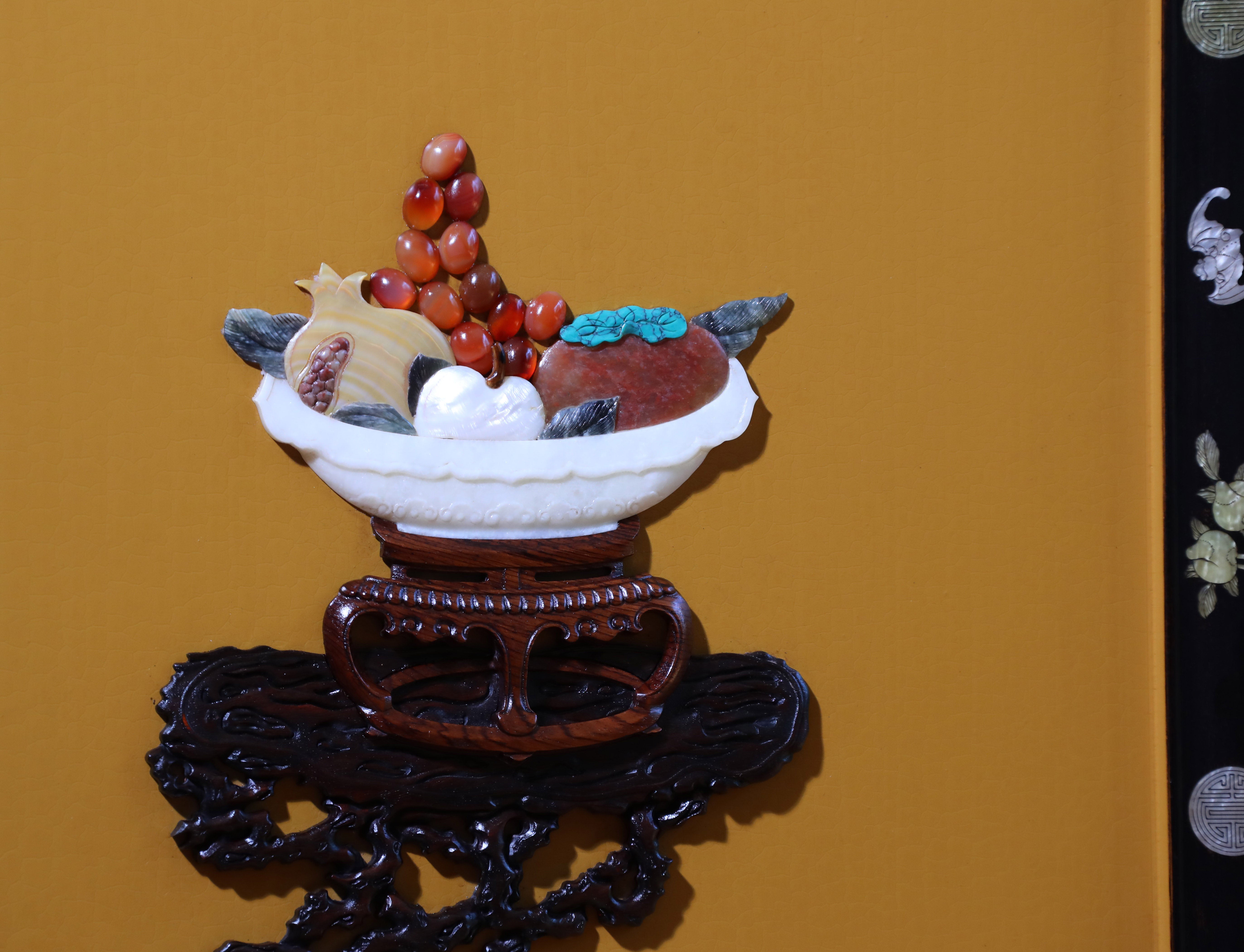 A hanging screen inlaid with precious stones, symbolizing peace and prosperity.