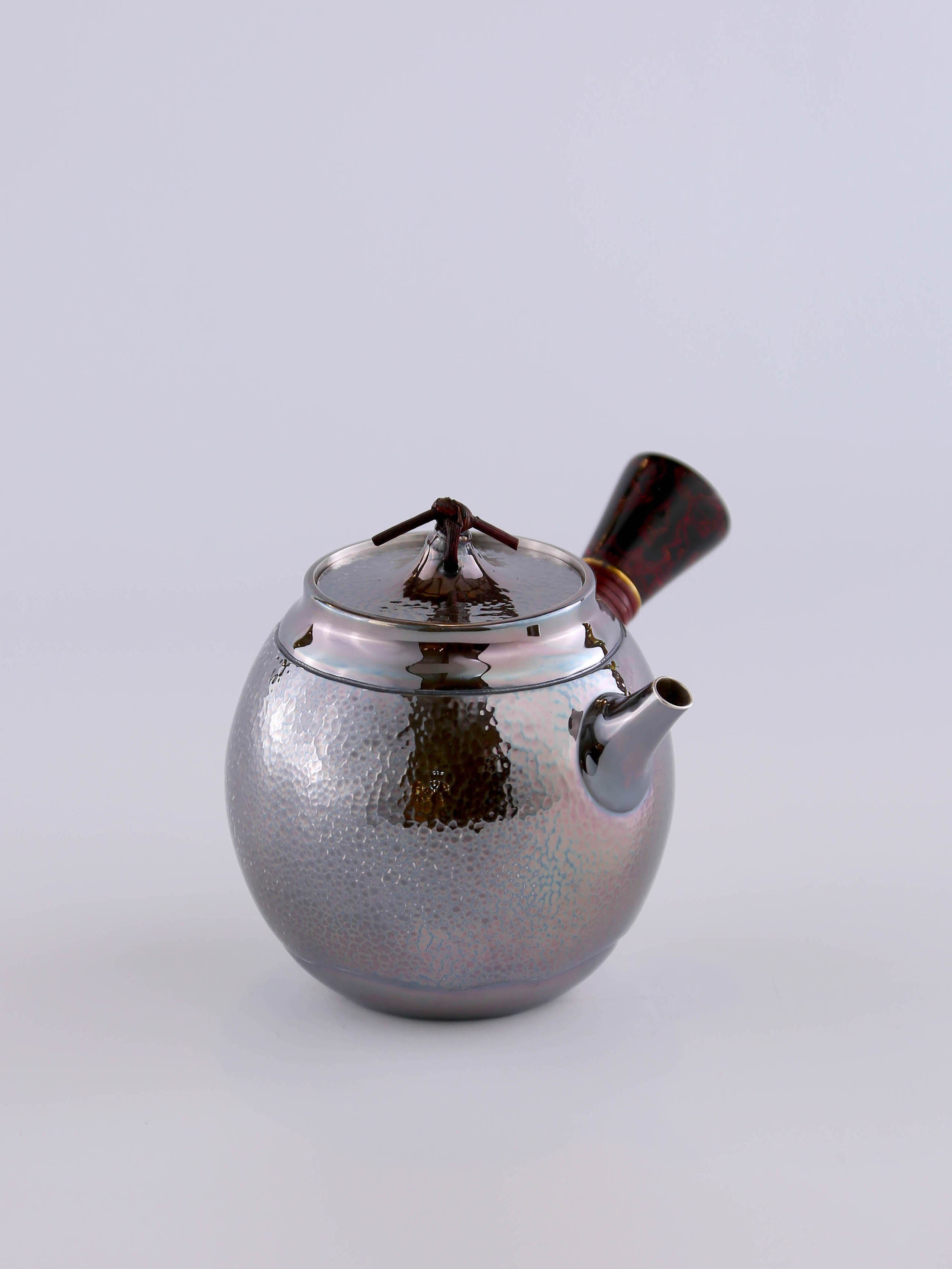 Hong Jike, an inheritor of the intangible cultural heritage, makes a lacquered, side-handled, pure silver teapot.