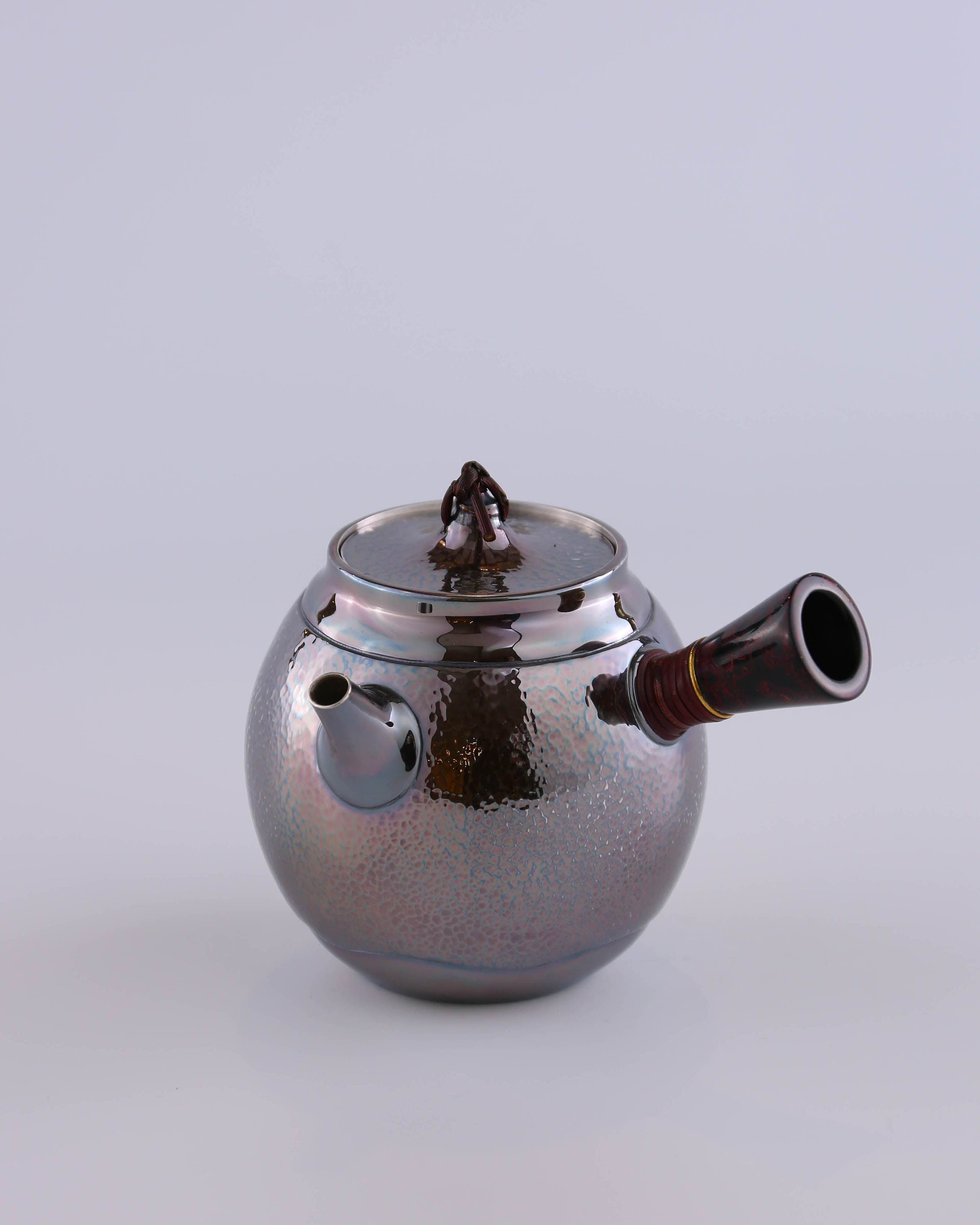 Hong Jike, an inheritor of the intangible cultural heritage, makes a lacquered, side-handled, pure silver teapot.