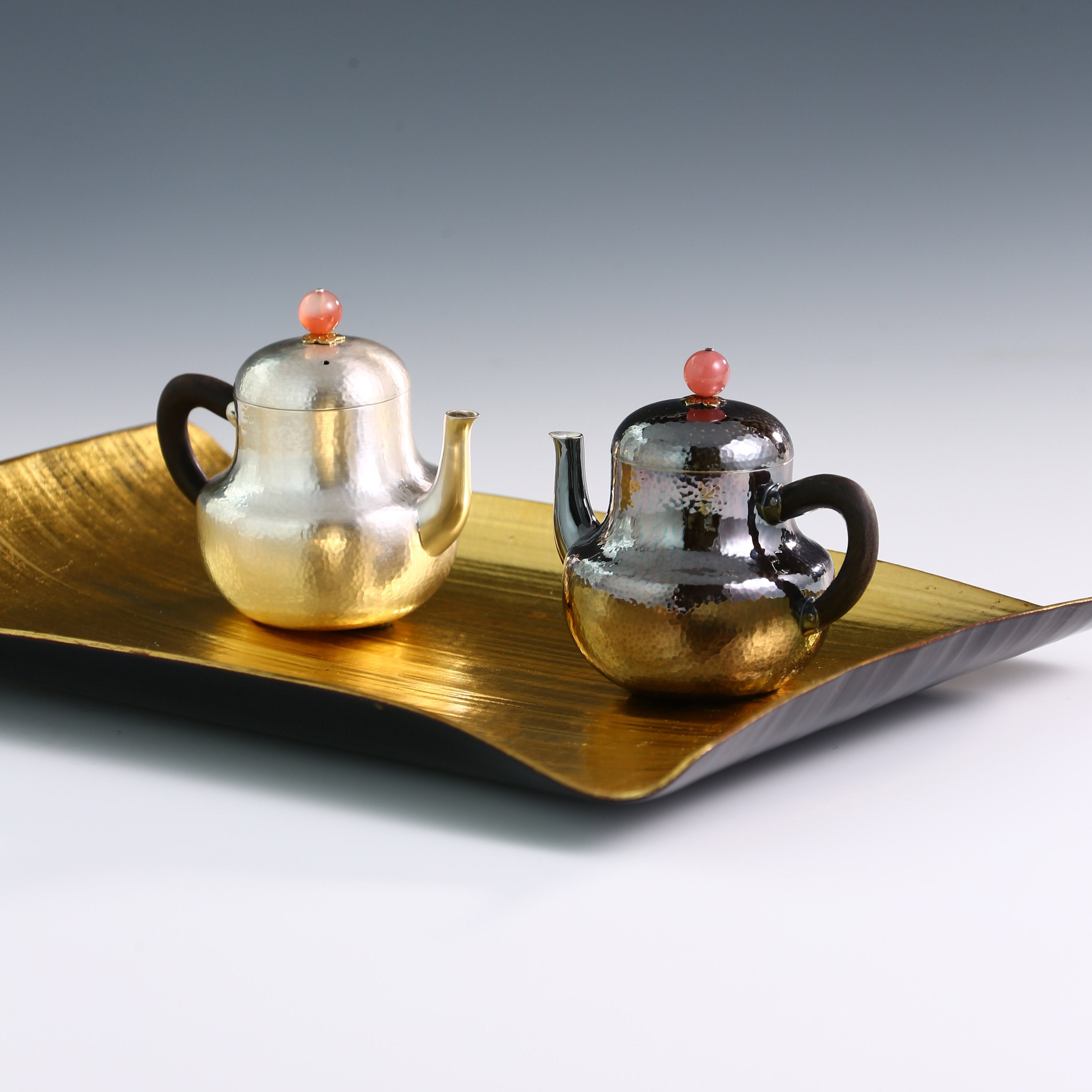 A pair of red-topped Siting sterling silver teapots