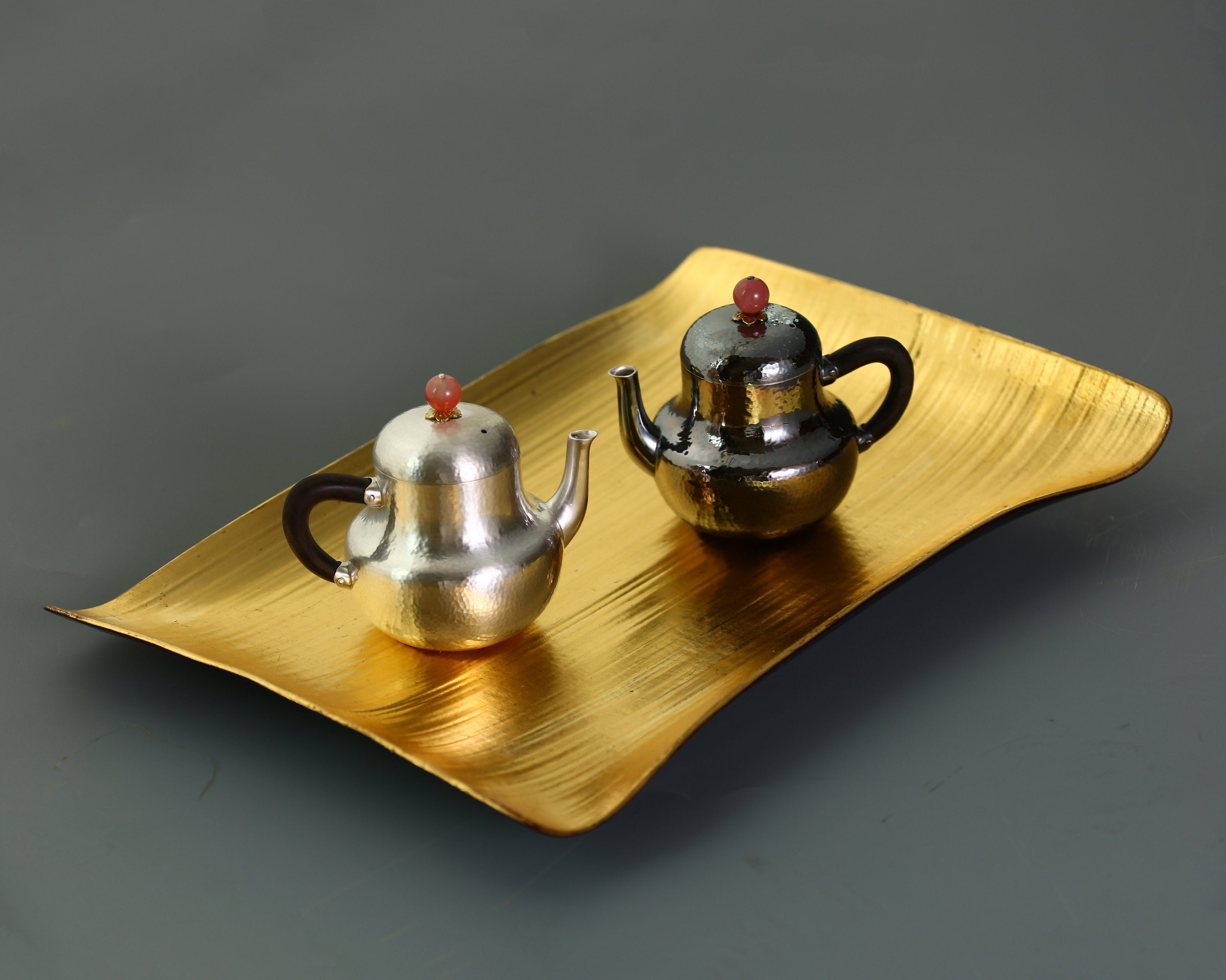 A pair of red-topped Siting sterling silver teapots