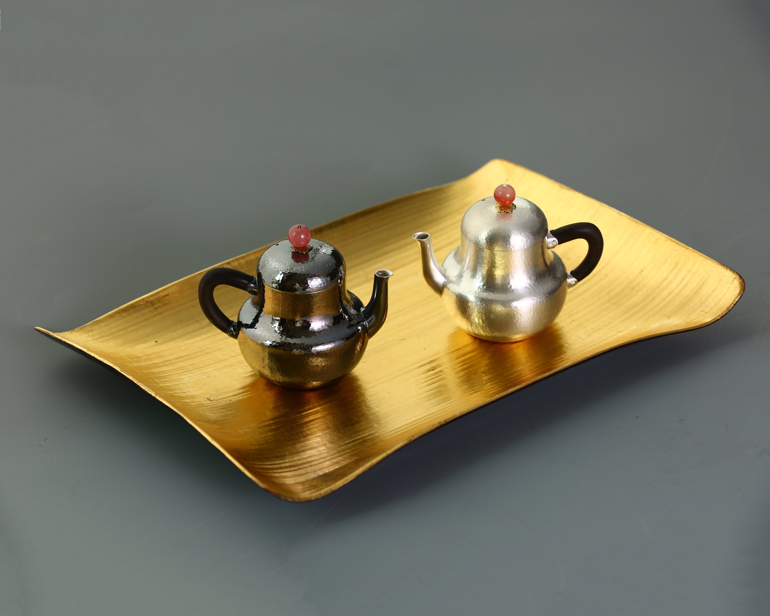 A pair of red-topped Siting sterling silver teapots