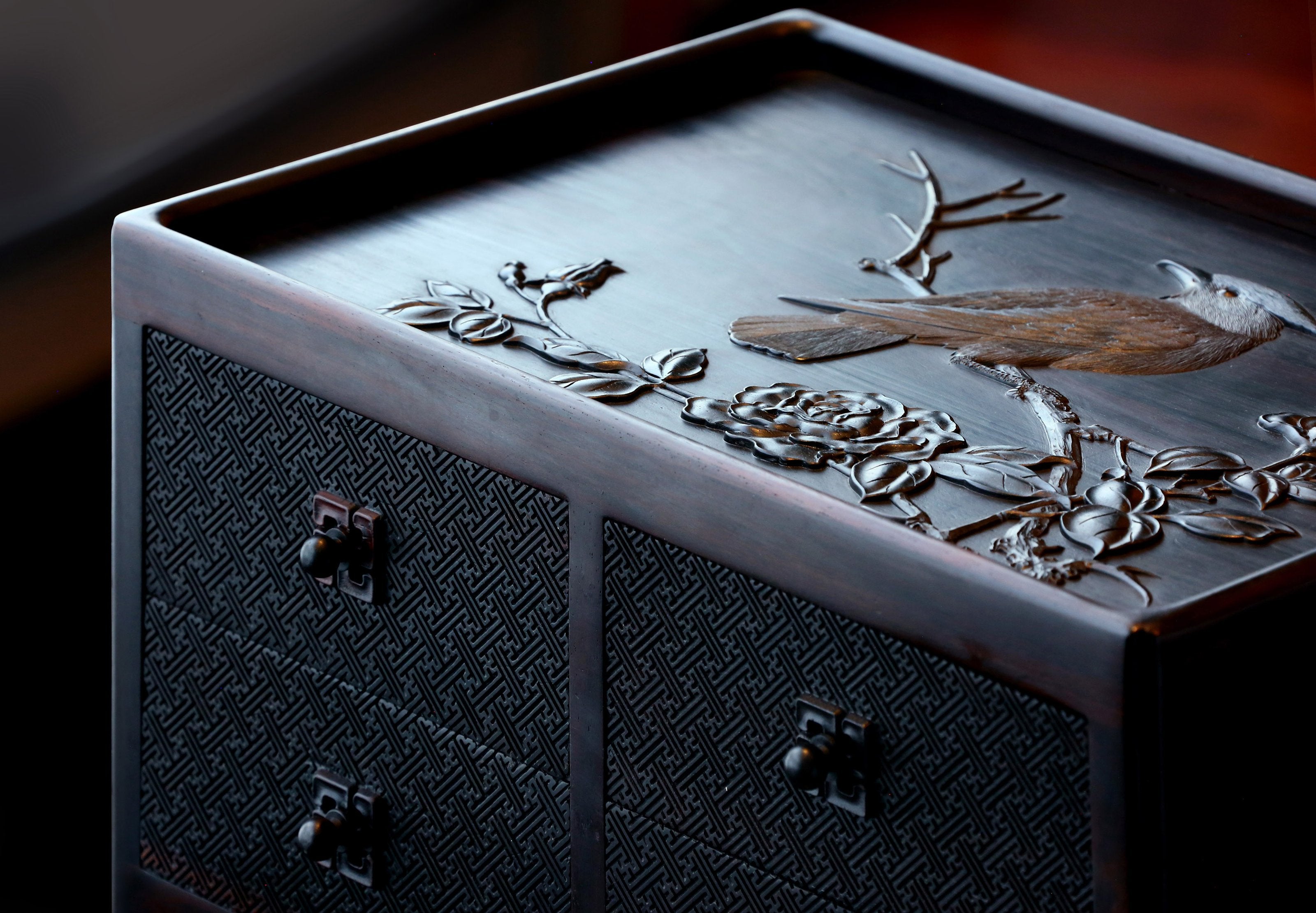 A four-drawer tea box carved from large-leaf sandalwood with silk feathers and hoopoe and swastika patterns.