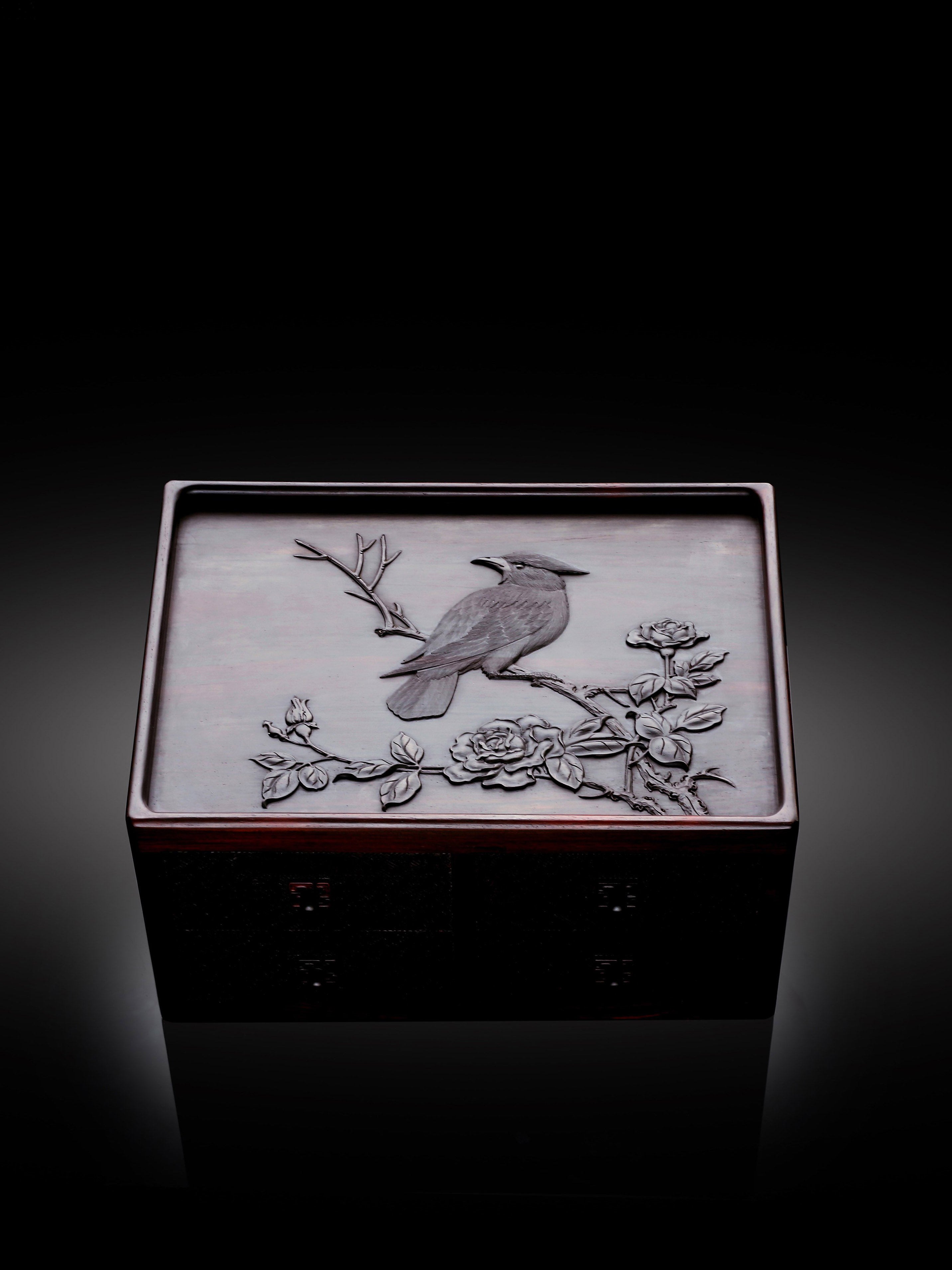 A four-drawer tea box carved from large-leaf sandalwood with silk feathers and hoopoe and swastika patterns.