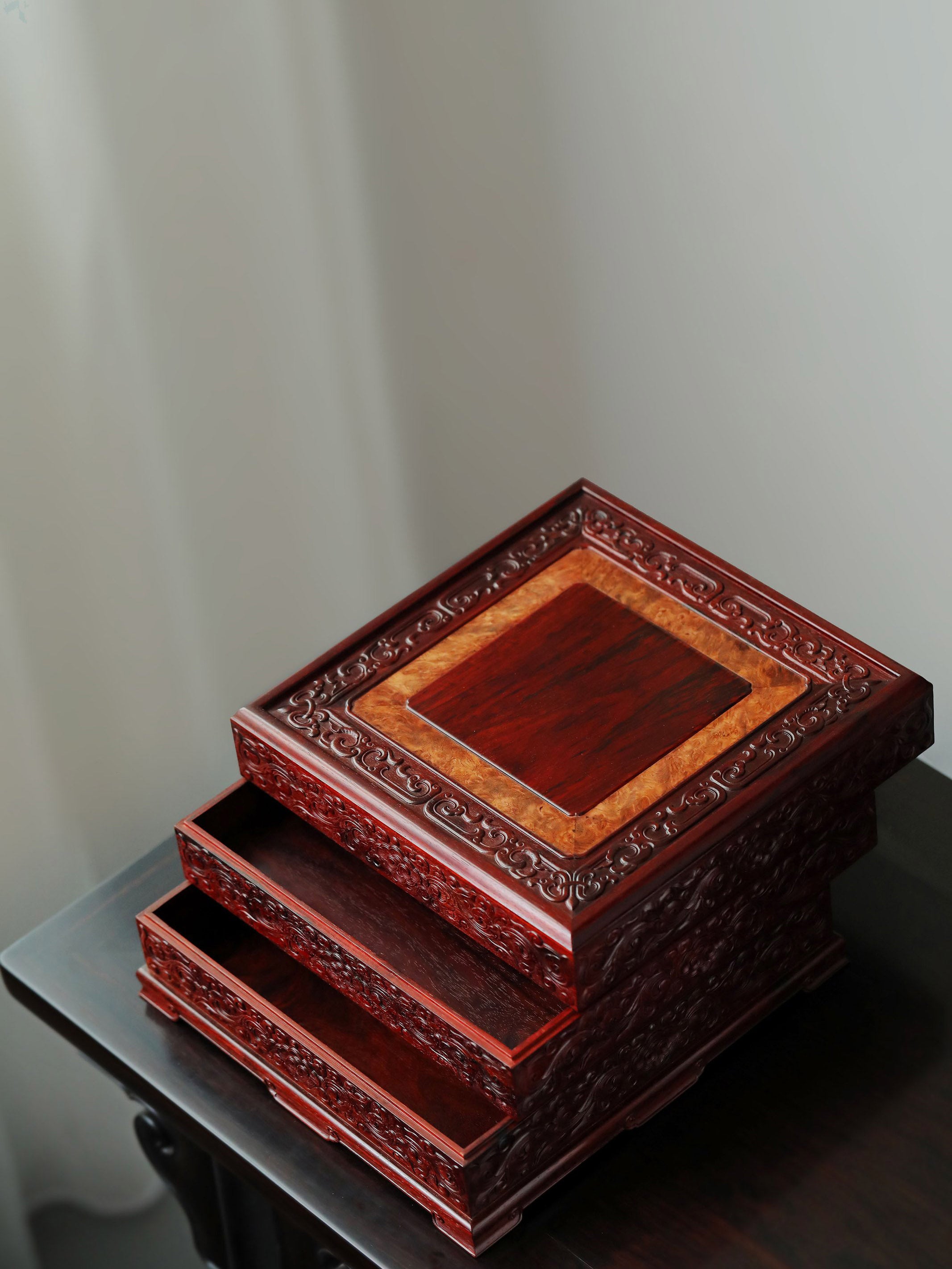 Small-leaf sandalwood tea box with auspicious cloud and scroll patterns, three-tiered lid and four corners.