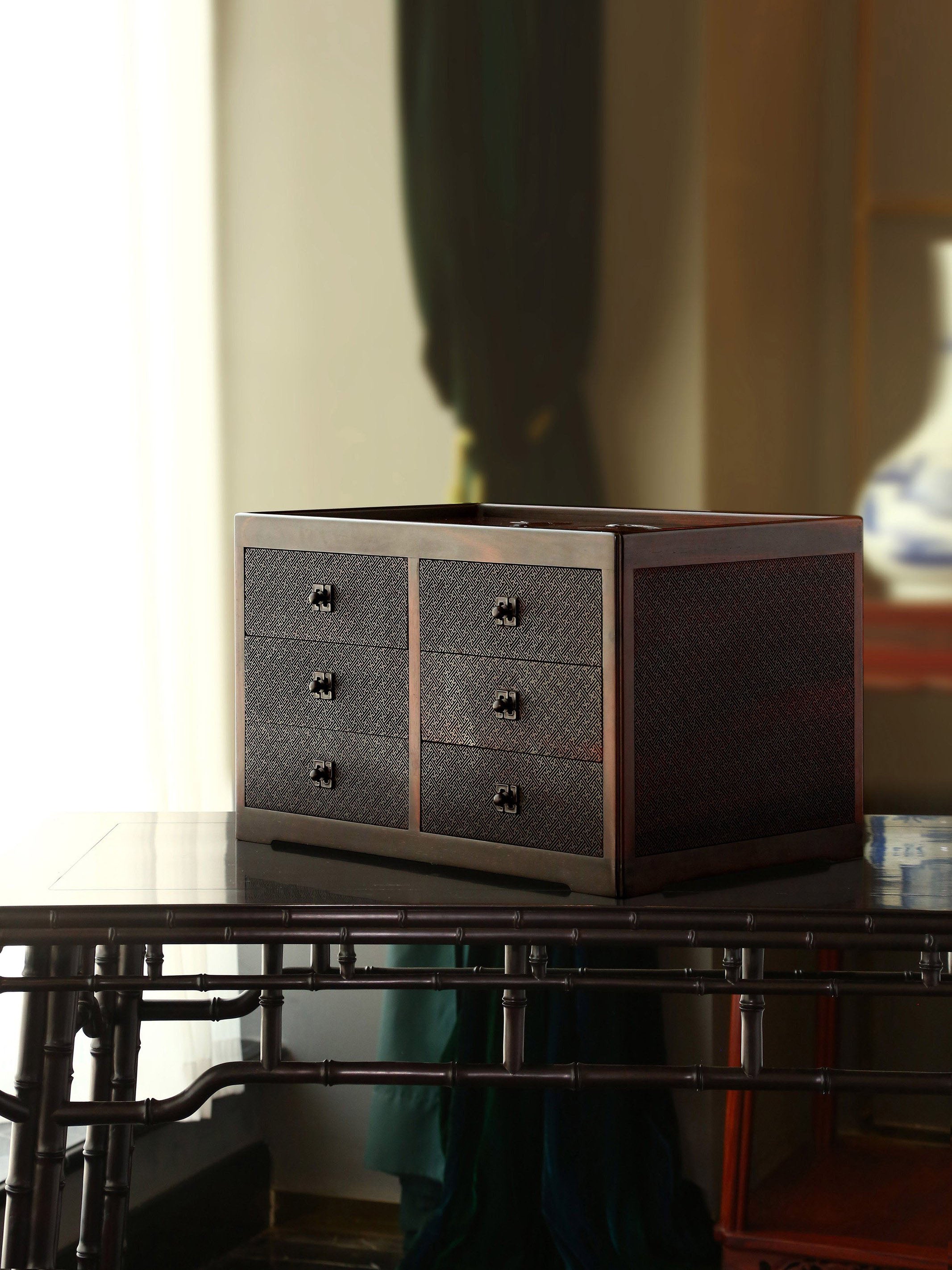 A six-drawer tea box carved with flowers, birds, and swastika patterns on large-leaf sandalwood.