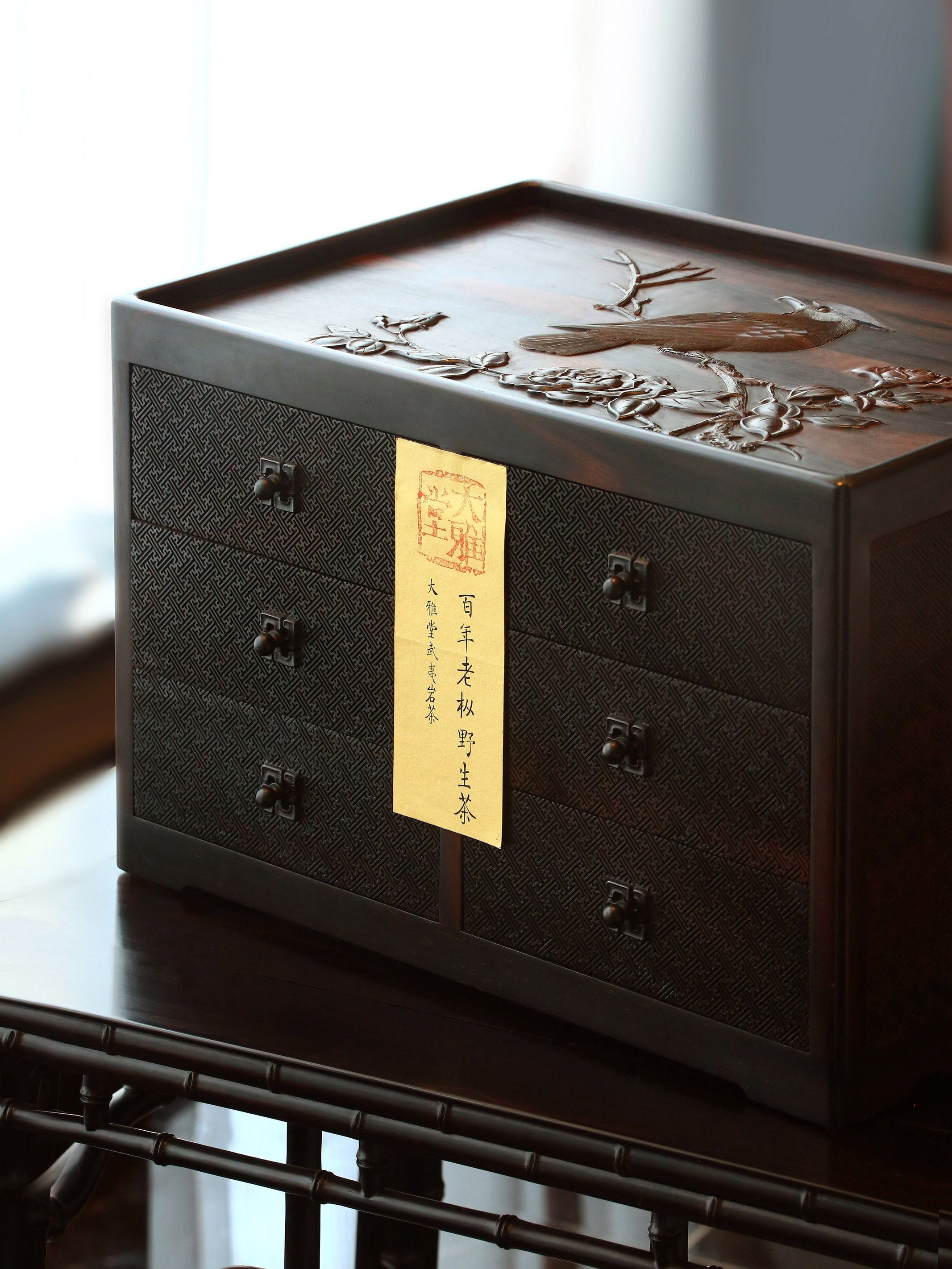 A six-drawer tea box carved with flowers, birds, and swastika patterns on large-leaf sandalwood.