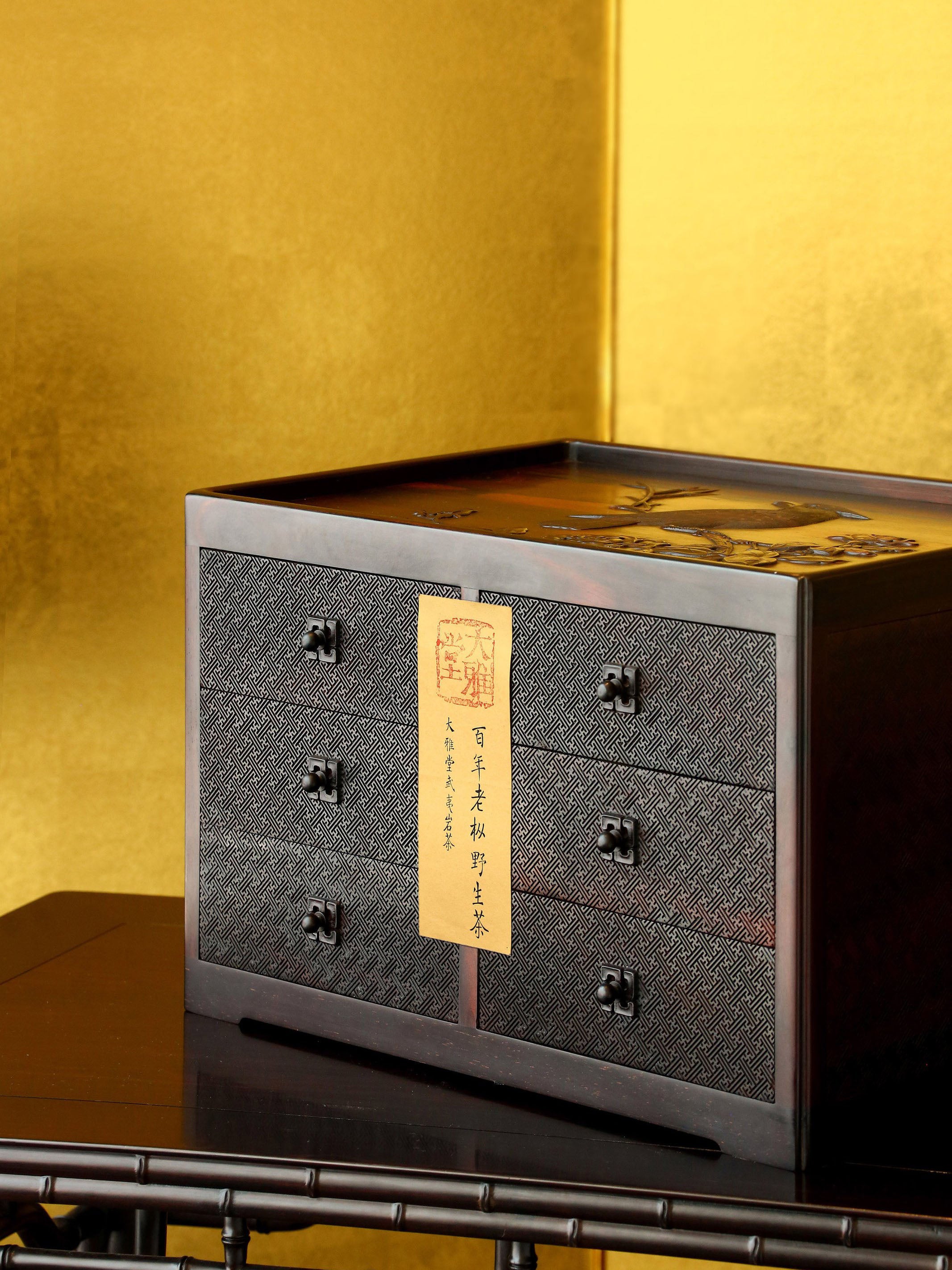 A six-drawer tea box carved with flowers, birds, and swastika patterns on large-leaf sandalwood.