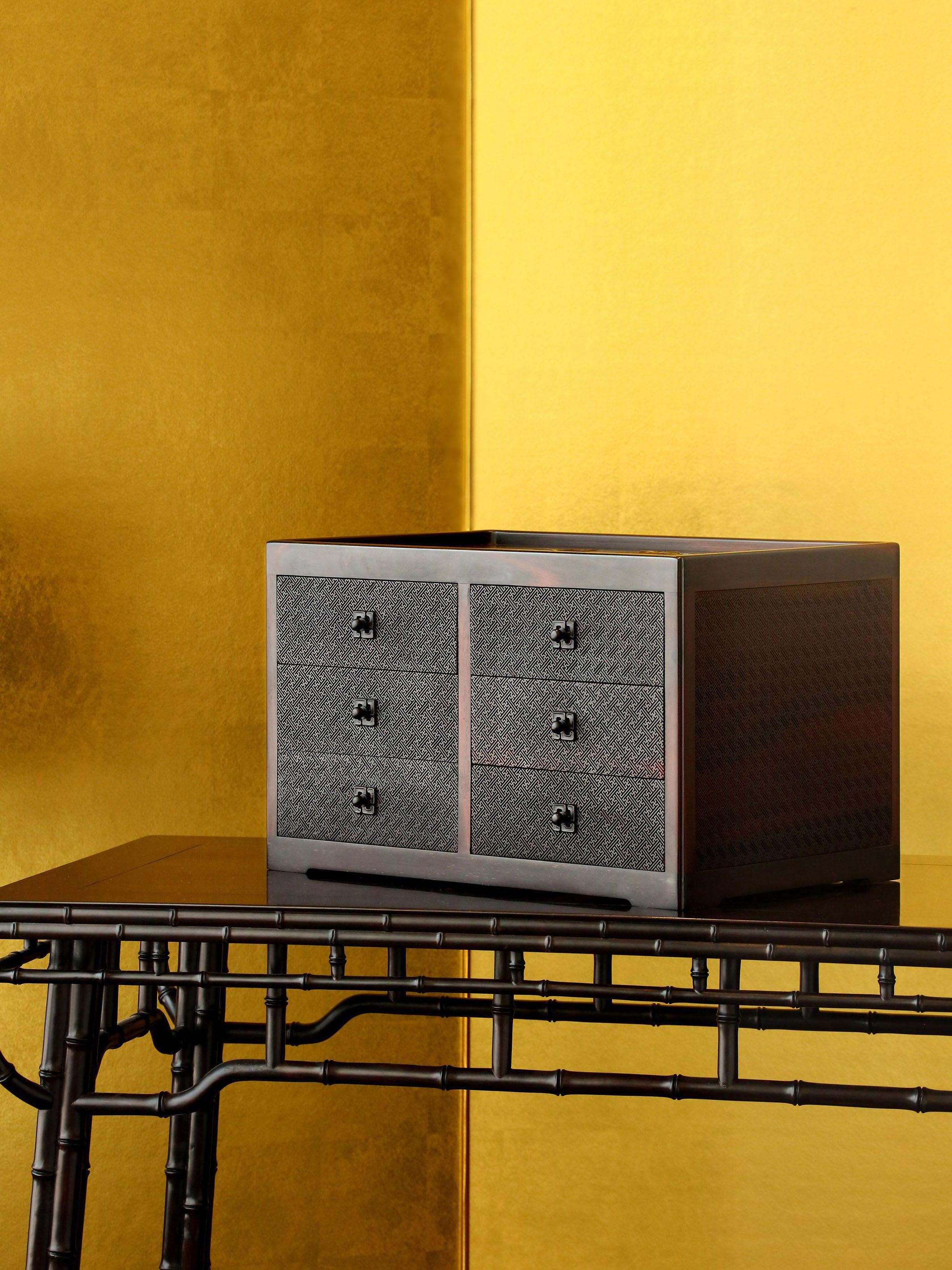 A six-drawer tea box carved with flowers, birds, and swastika patterns on large-leaf sandalwood.