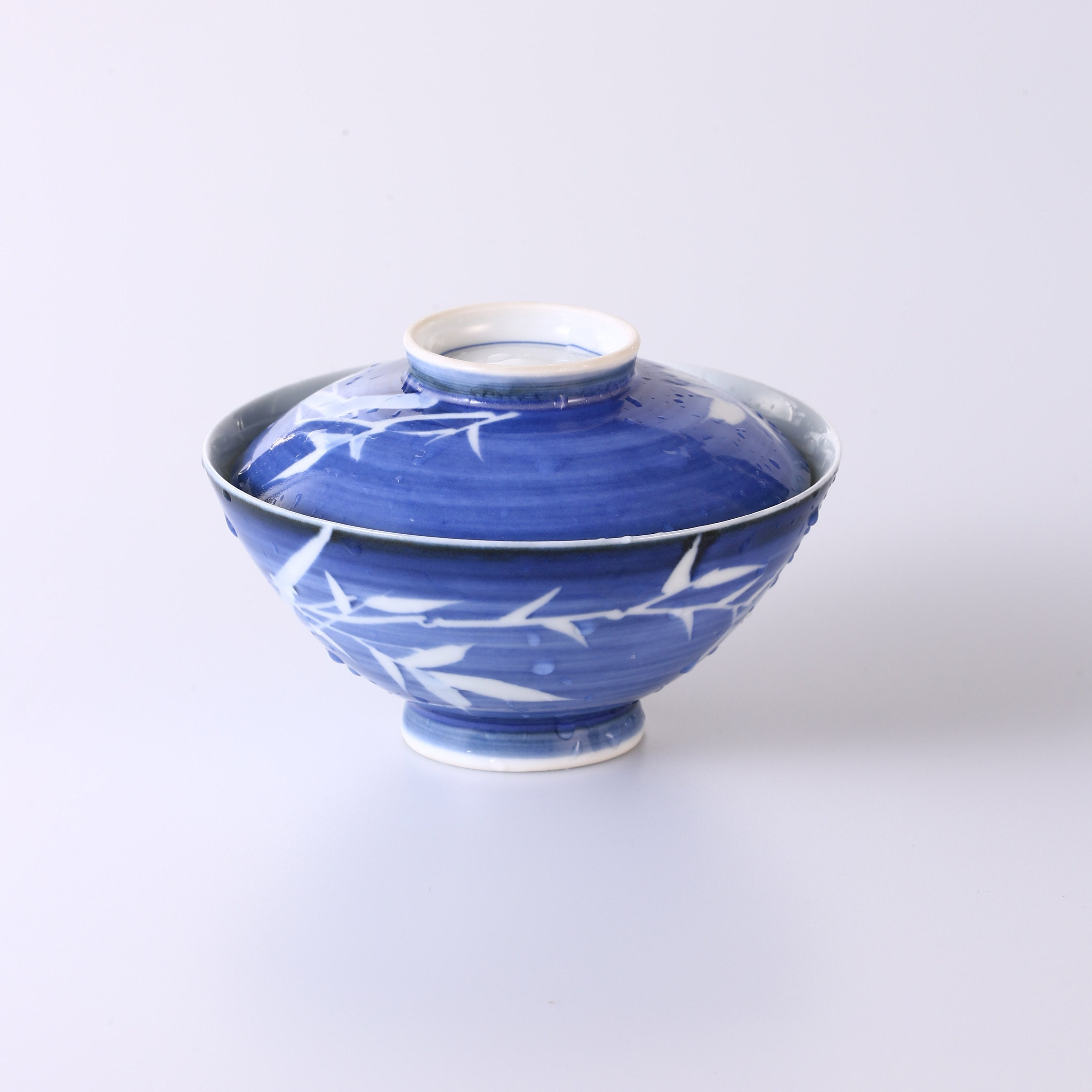 Blue and white porcelain covered bowl with water features, reflecting noble character and integrity.