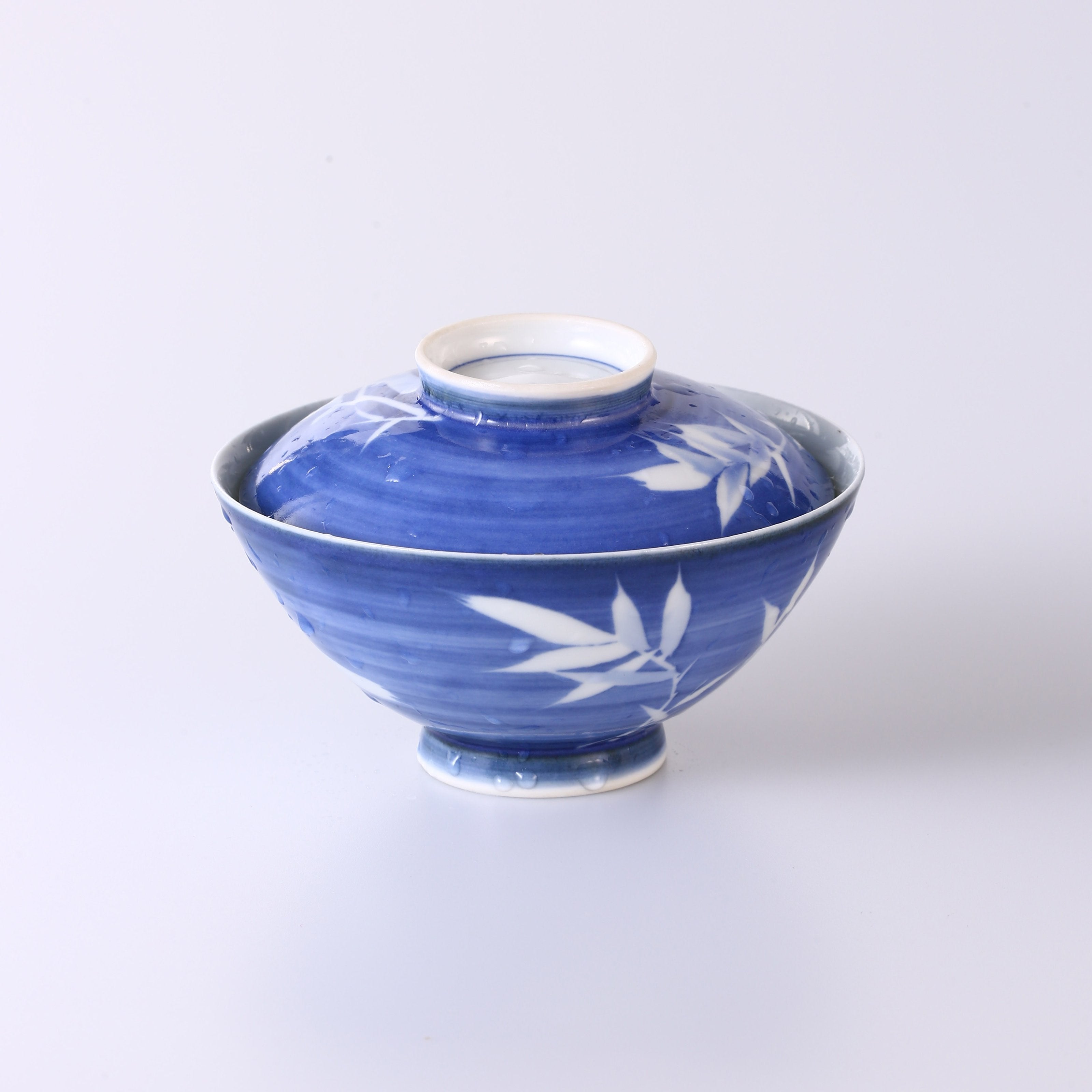 Blue and white porcelain covered bowl with water features, reflecting noble character and integrity.