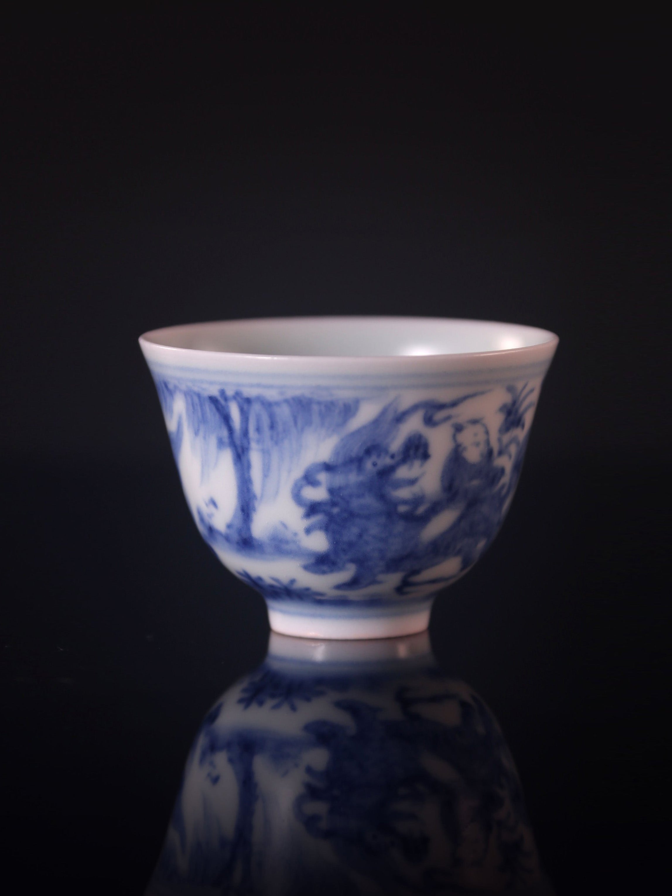 Blue and white porcelain cup with a unicorn and a child