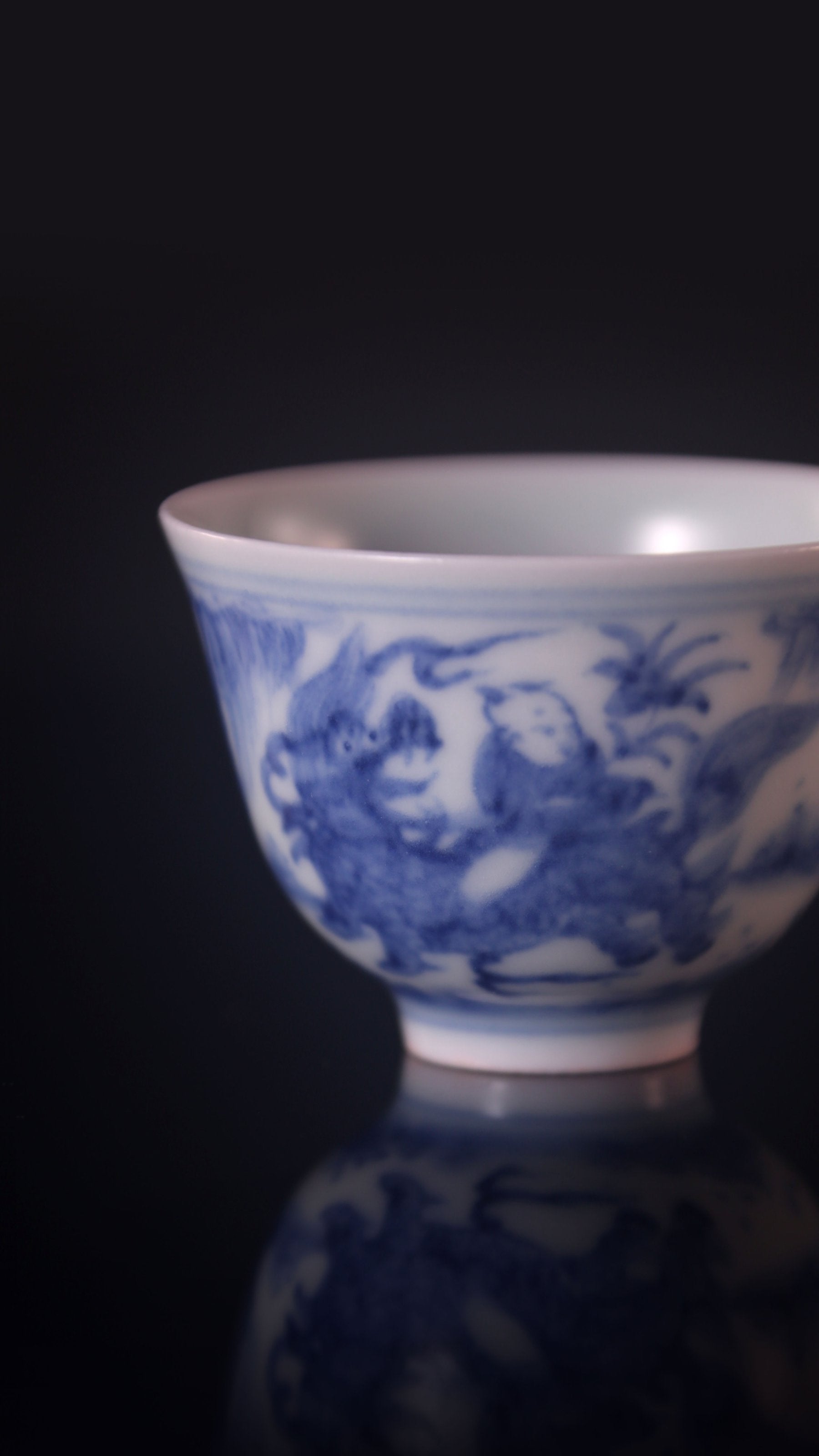 Blue and white porcelain cup with a unicorn and a child