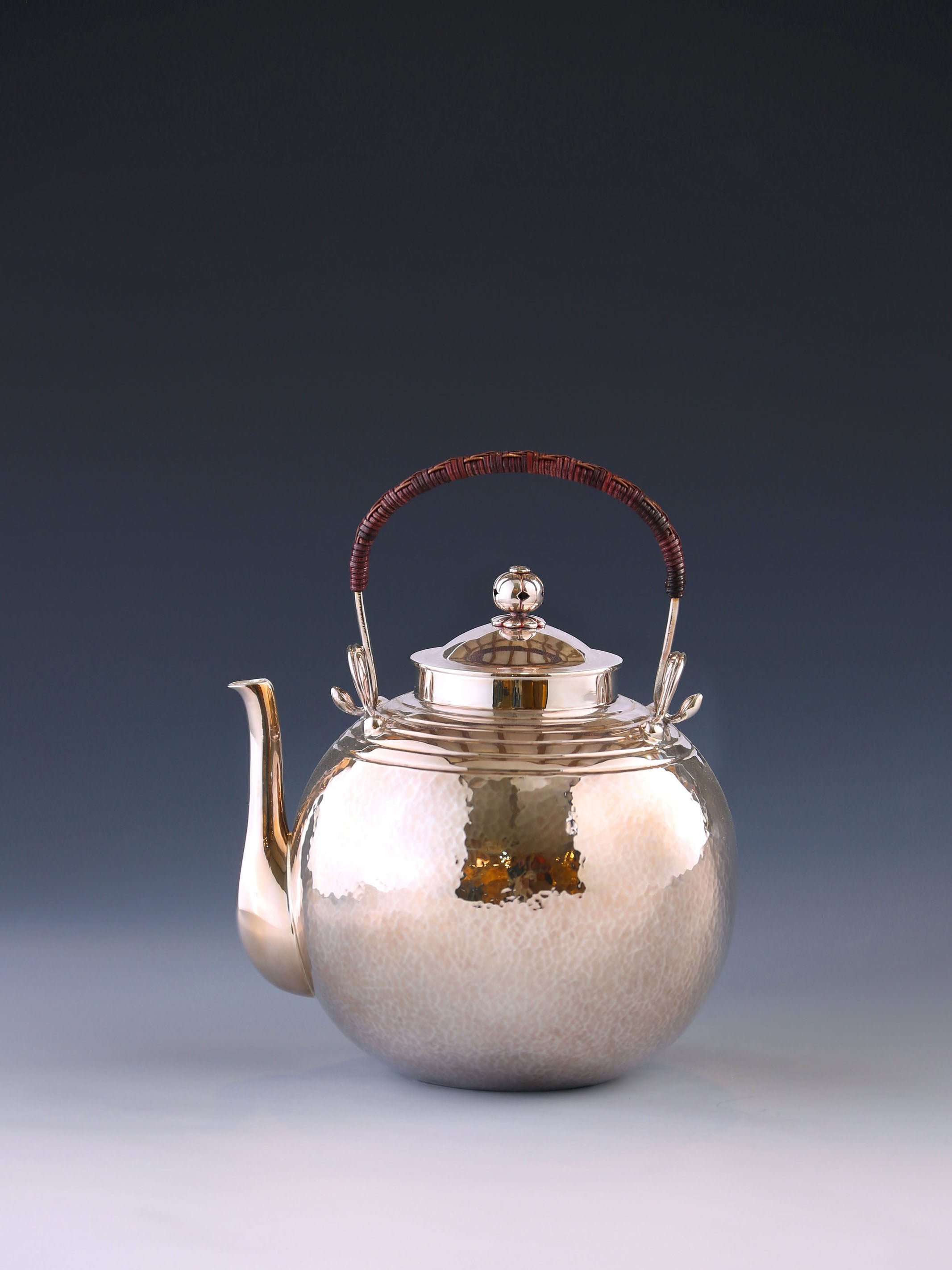 Round-shaped hammered silver teapot