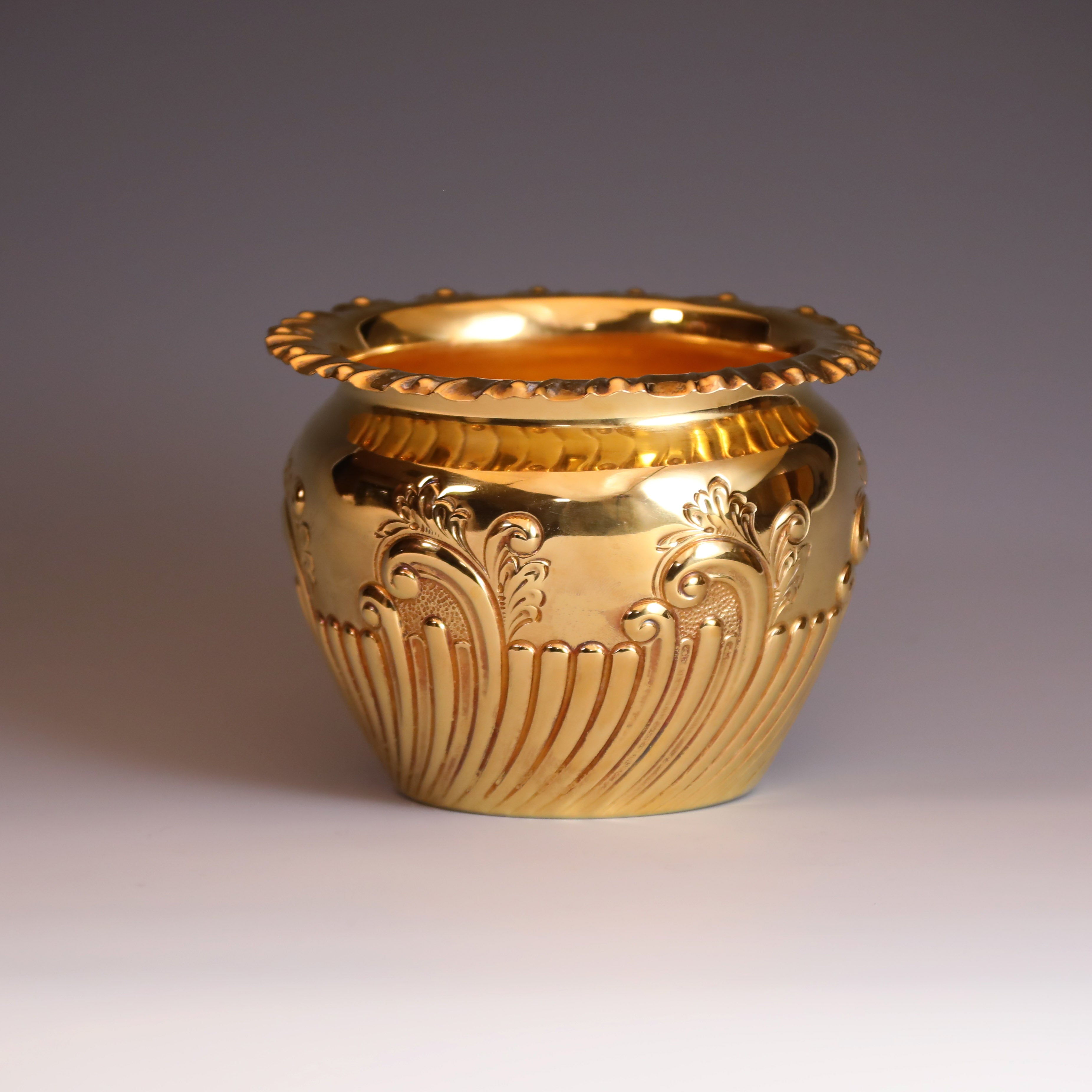 A sterling silver gilt scroll-patterned water dropper from Sheffield, England, between 1904 and 1905.