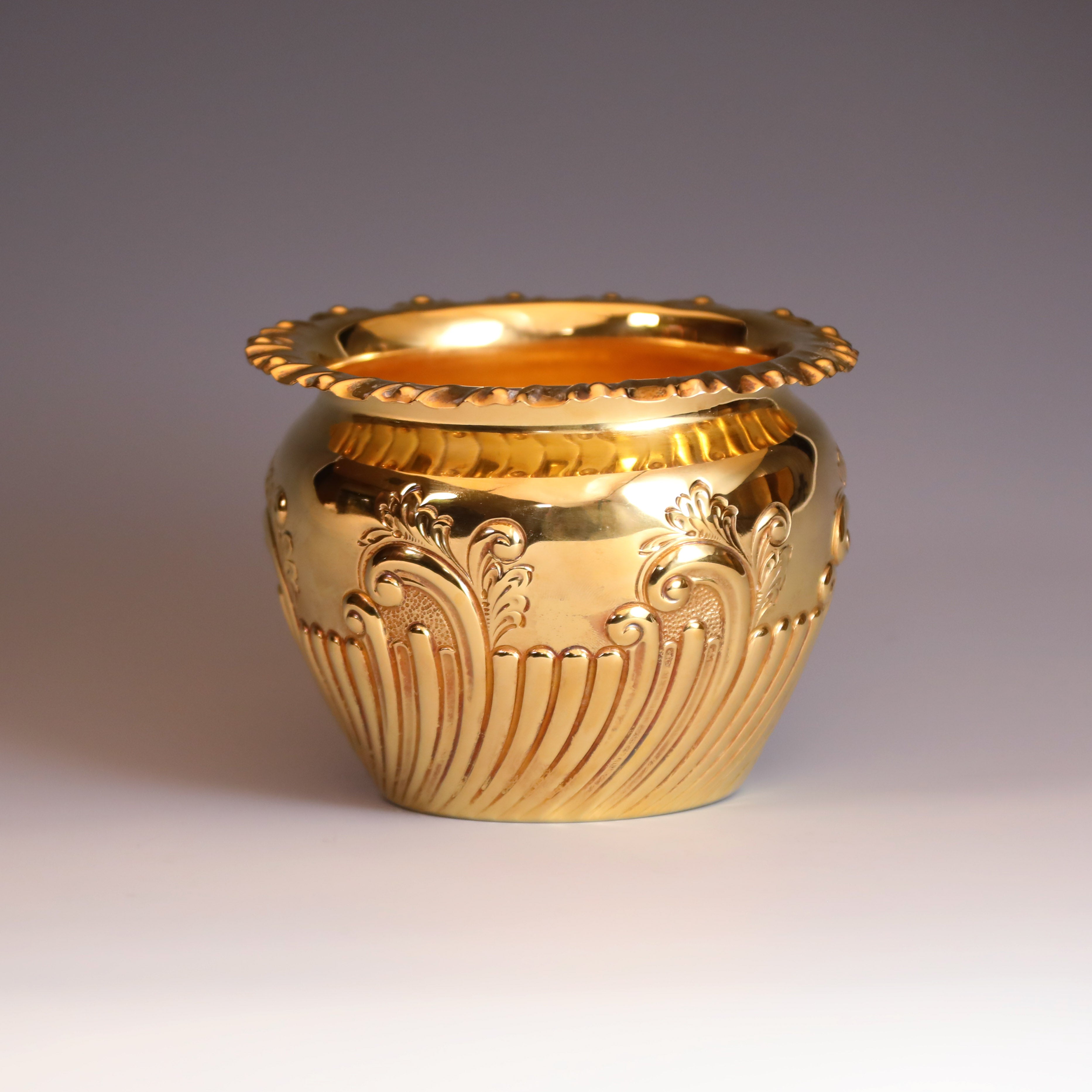 A sterling silver gilt scroll-patterned water dropper from Sheffield, England, between 1904 and 1905.