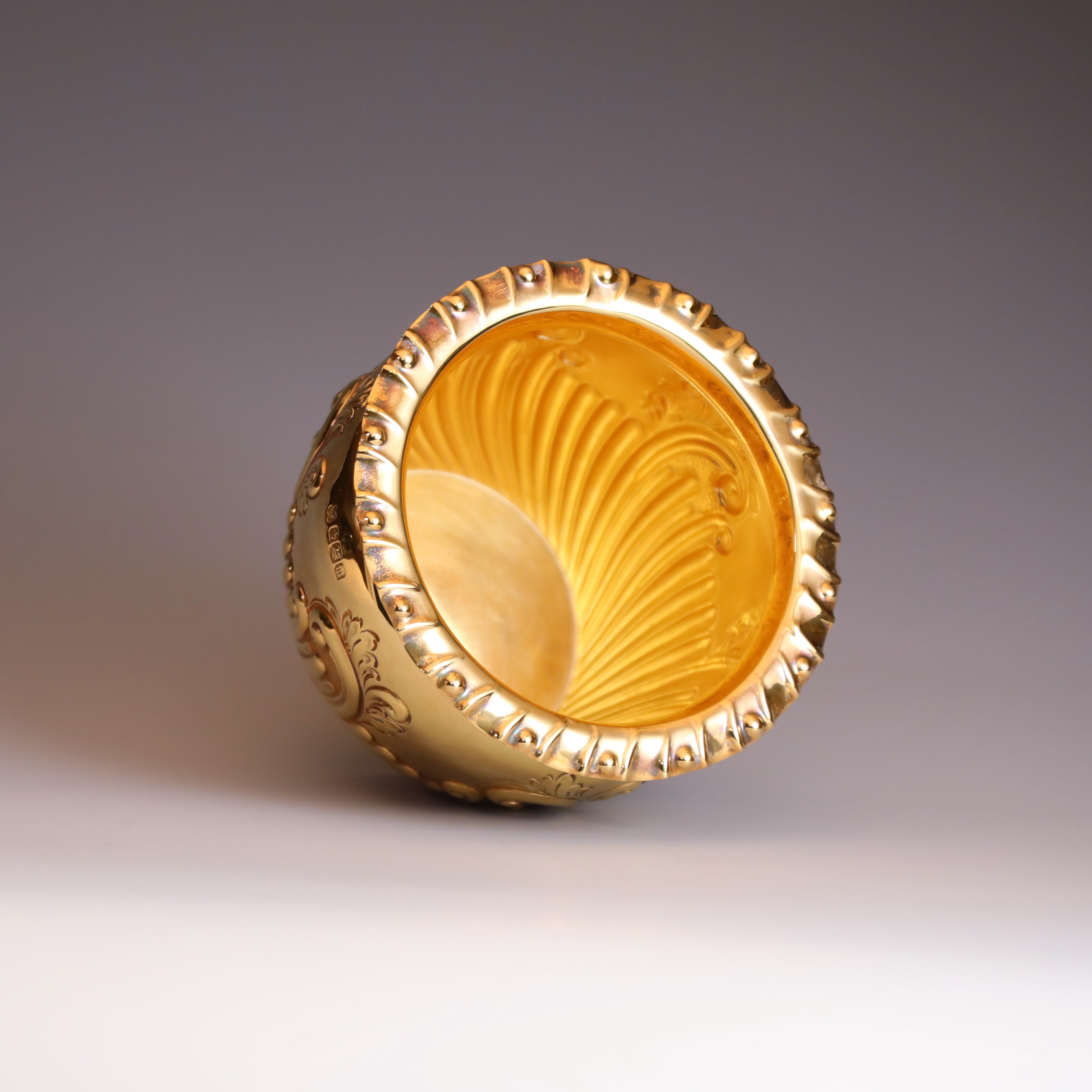 A sterling silver gilt scroll-patterned water dropper from Sheffield, England, between 1904 and 1905.