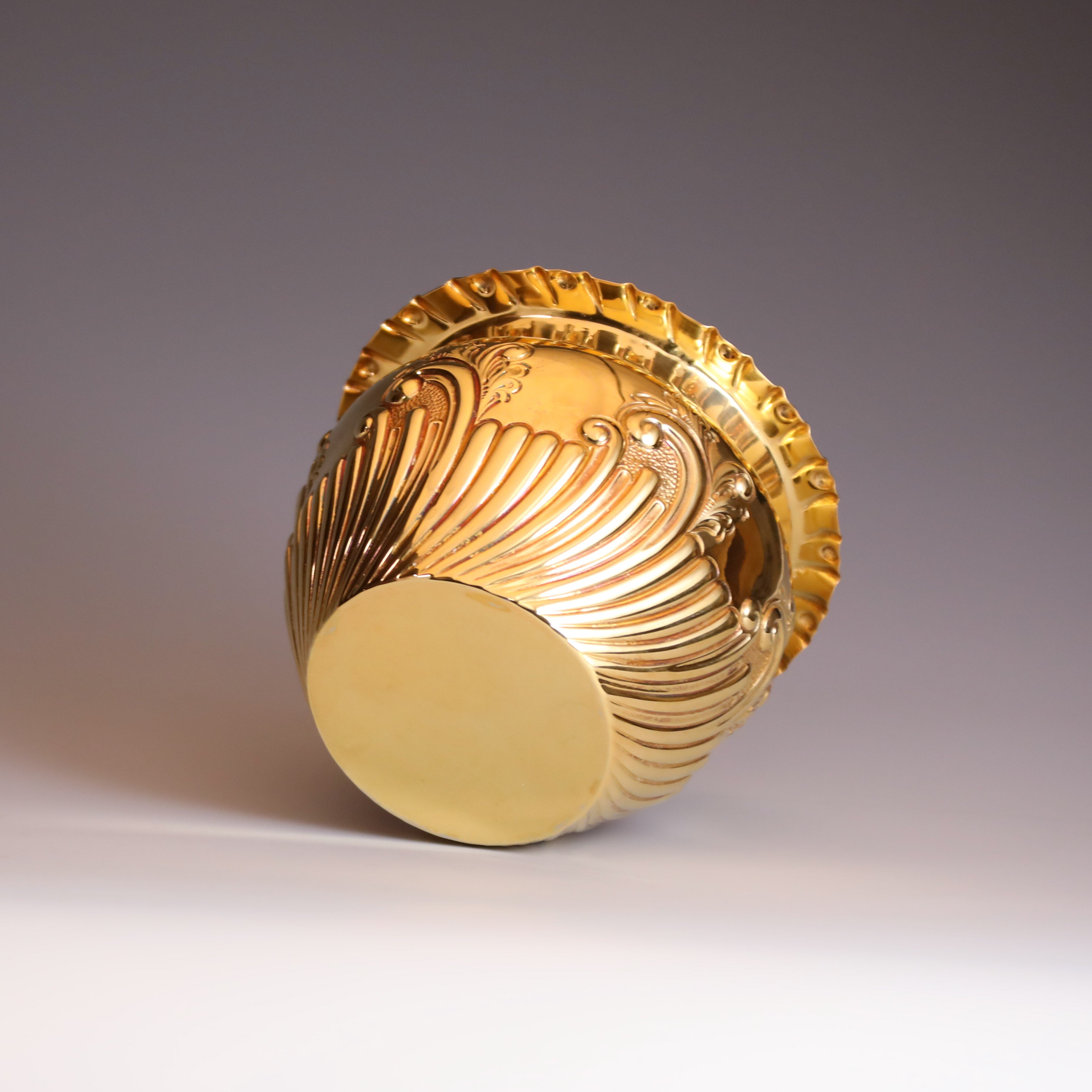 A sterling silver gilt scroll-patterned water dropper from Sheffield, England, between 1904 and 1905.