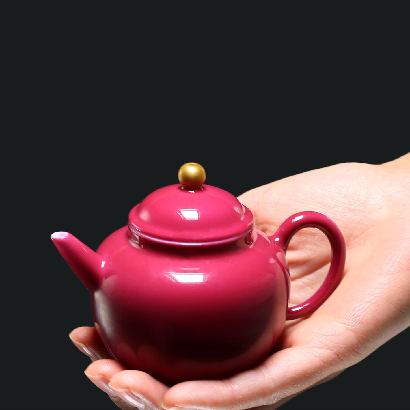 A red-knobbed, gold-decorated teapot
