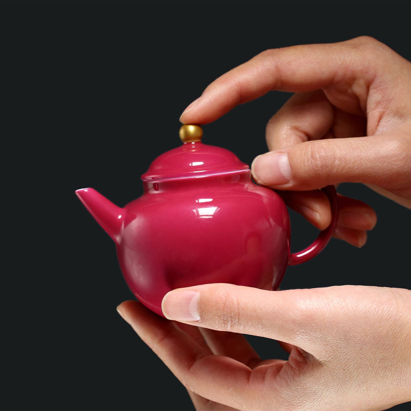 A red-knobbed, gold-decorated teapot