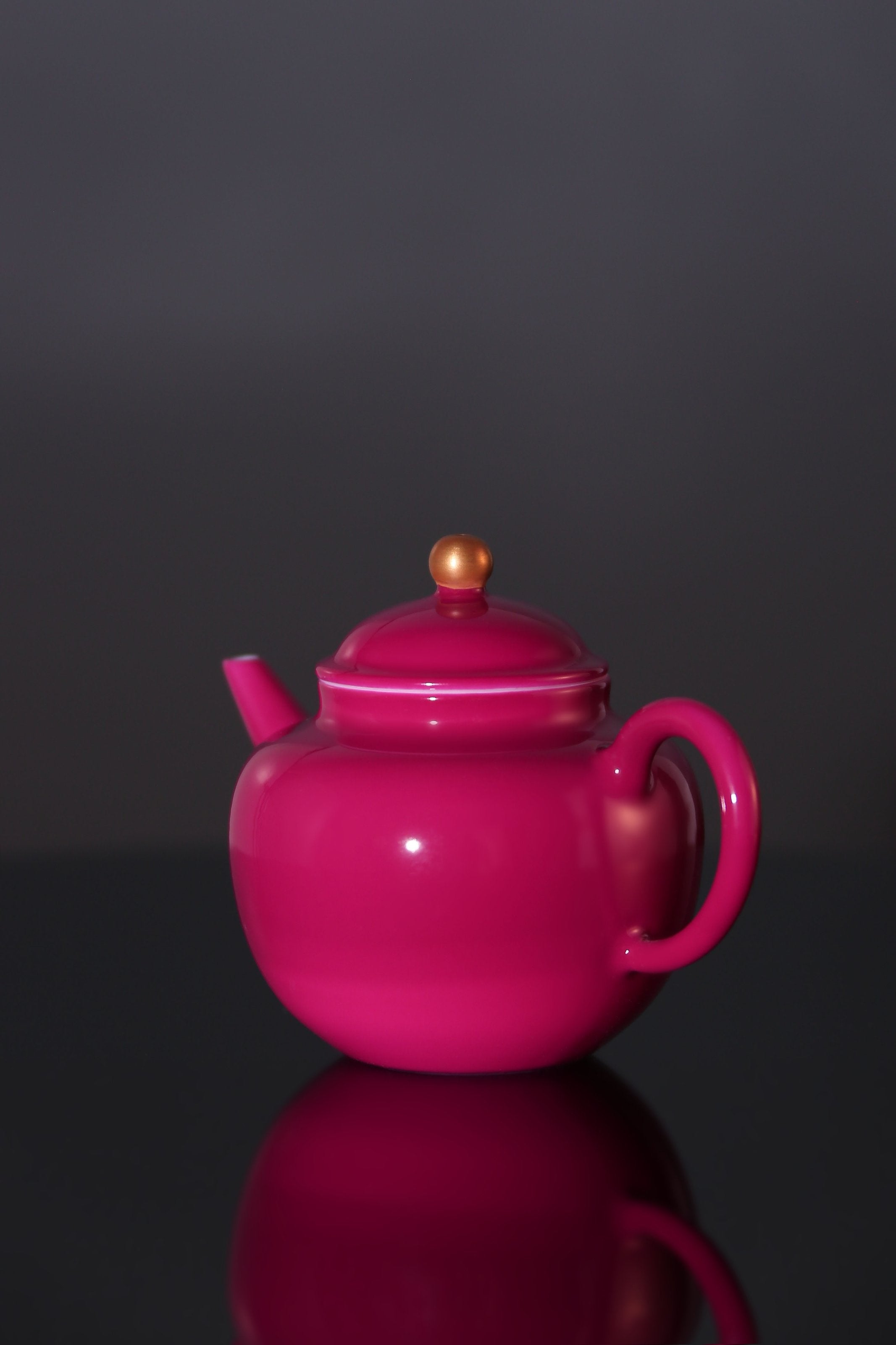 A red-knobbed, gold-decorated teapot