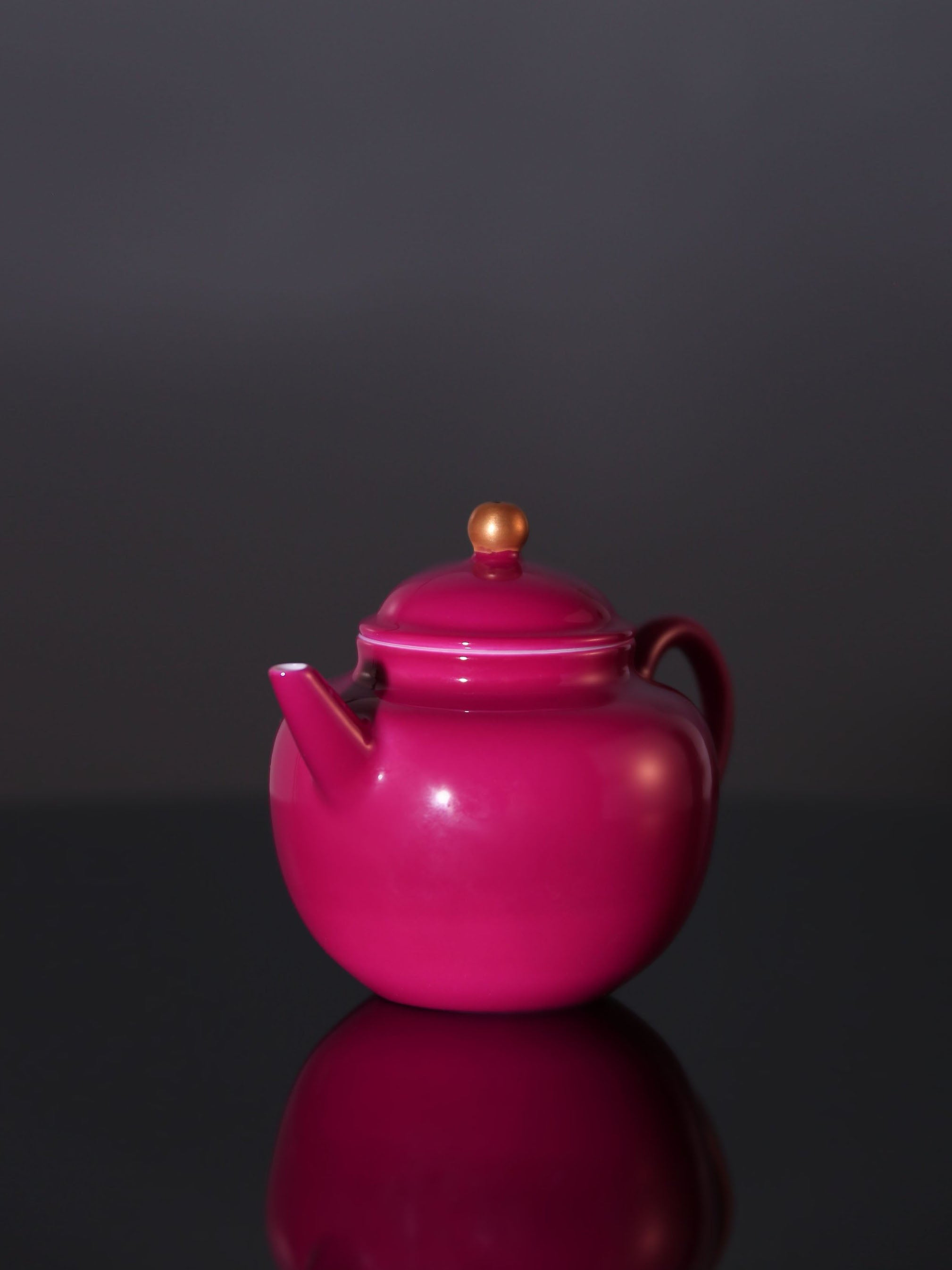 A red-knobbed, gold-decorated teapot