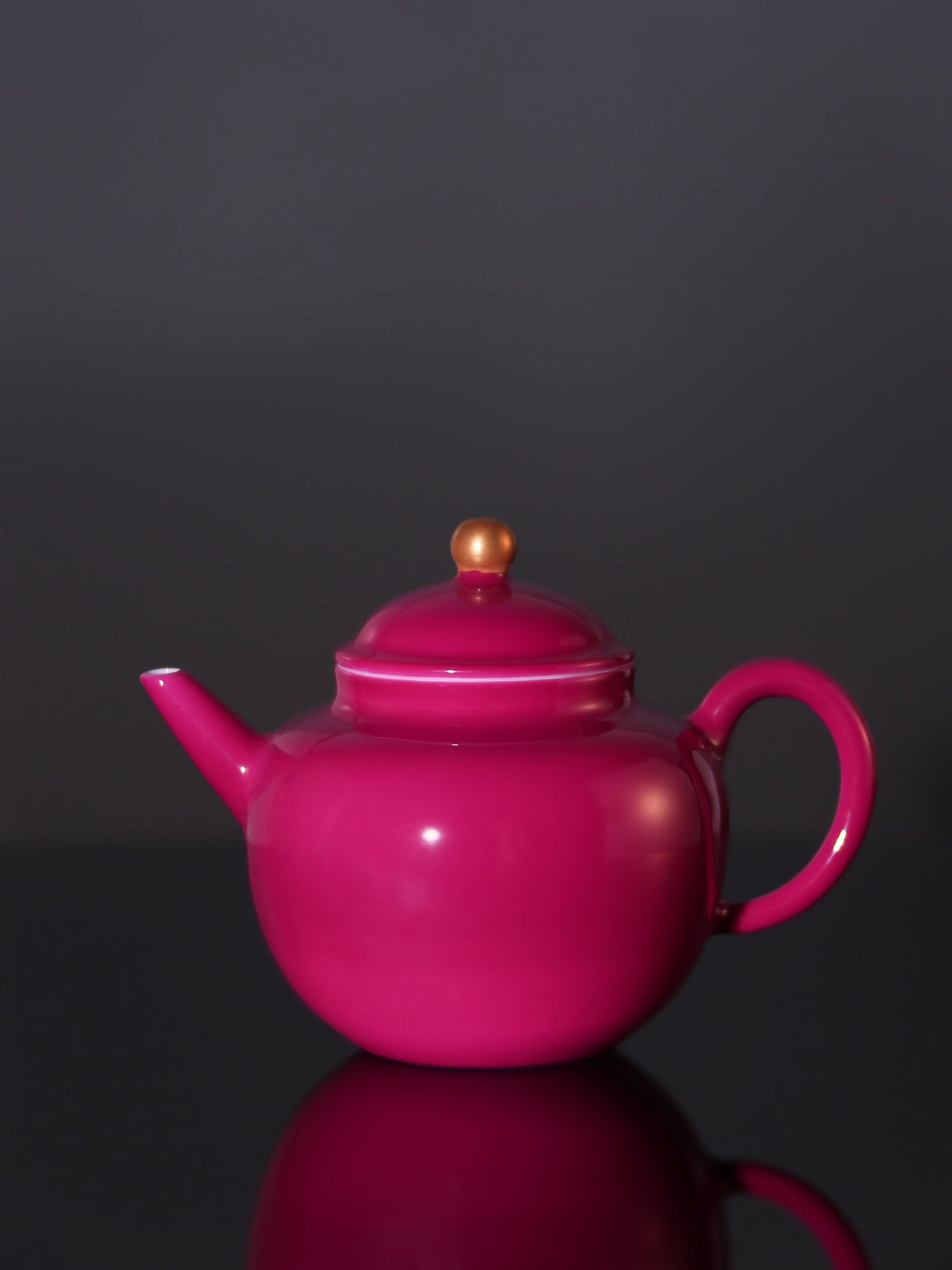 A red-knobbed, gold-decorated teapot