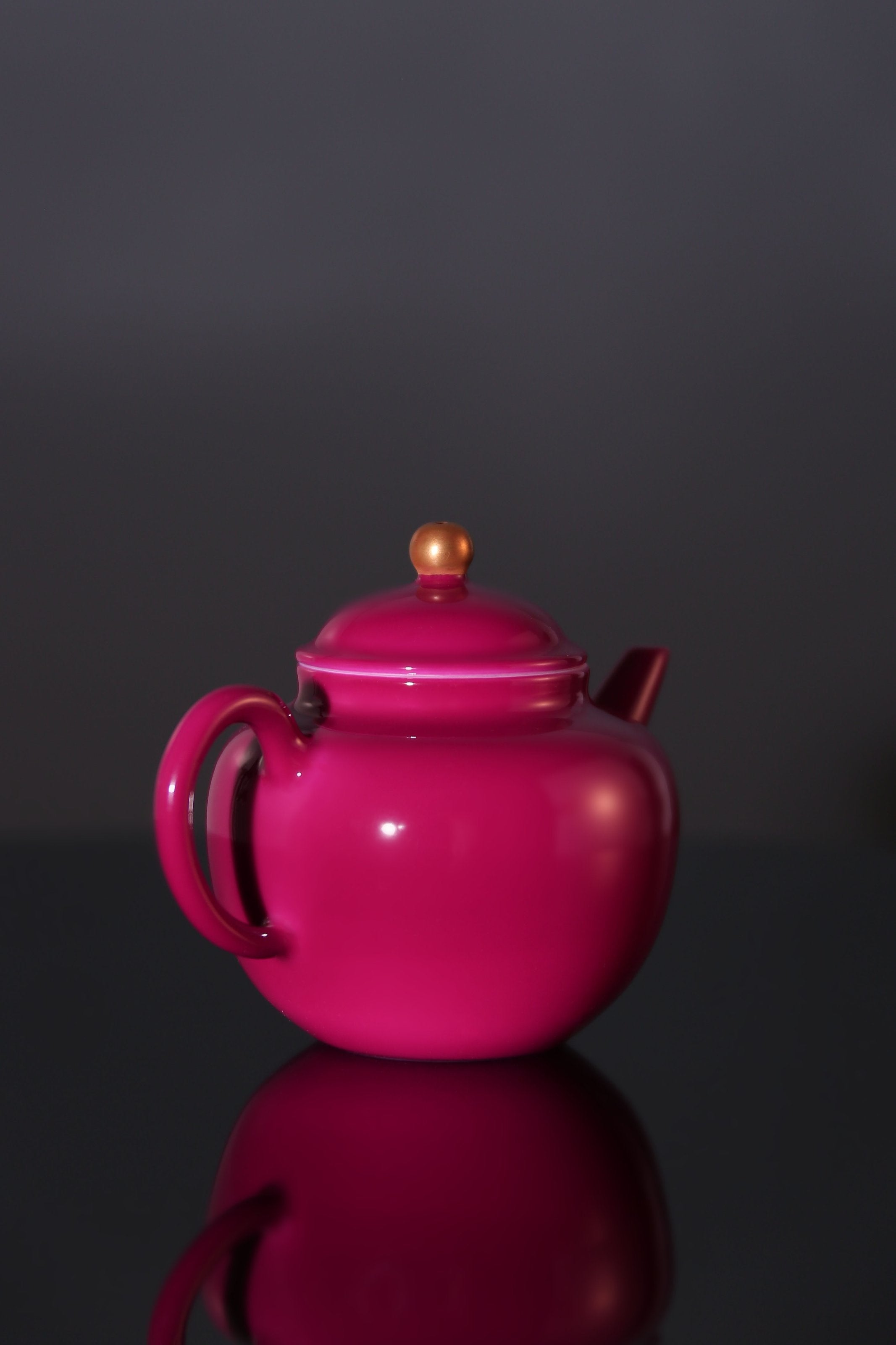 A red-knobbed, gold-decorated teapot