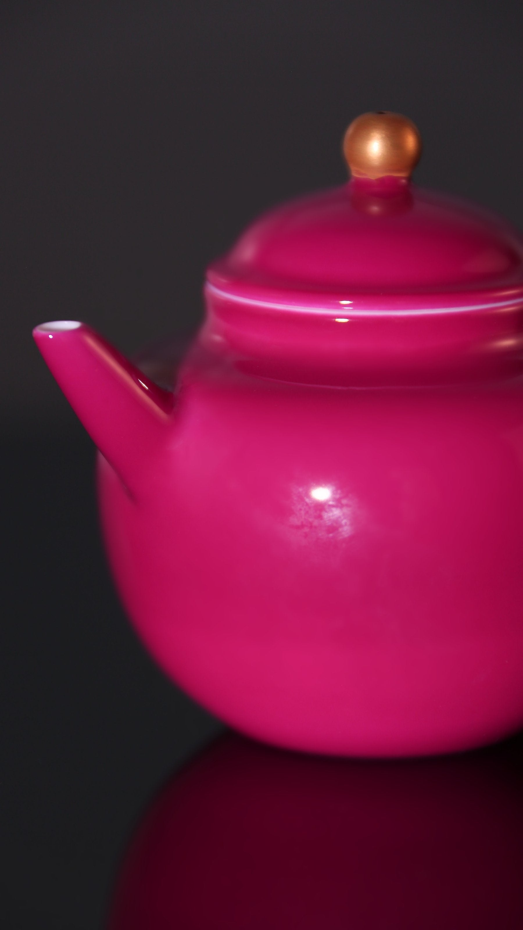 A red-knobbed, gold-decorated teapot