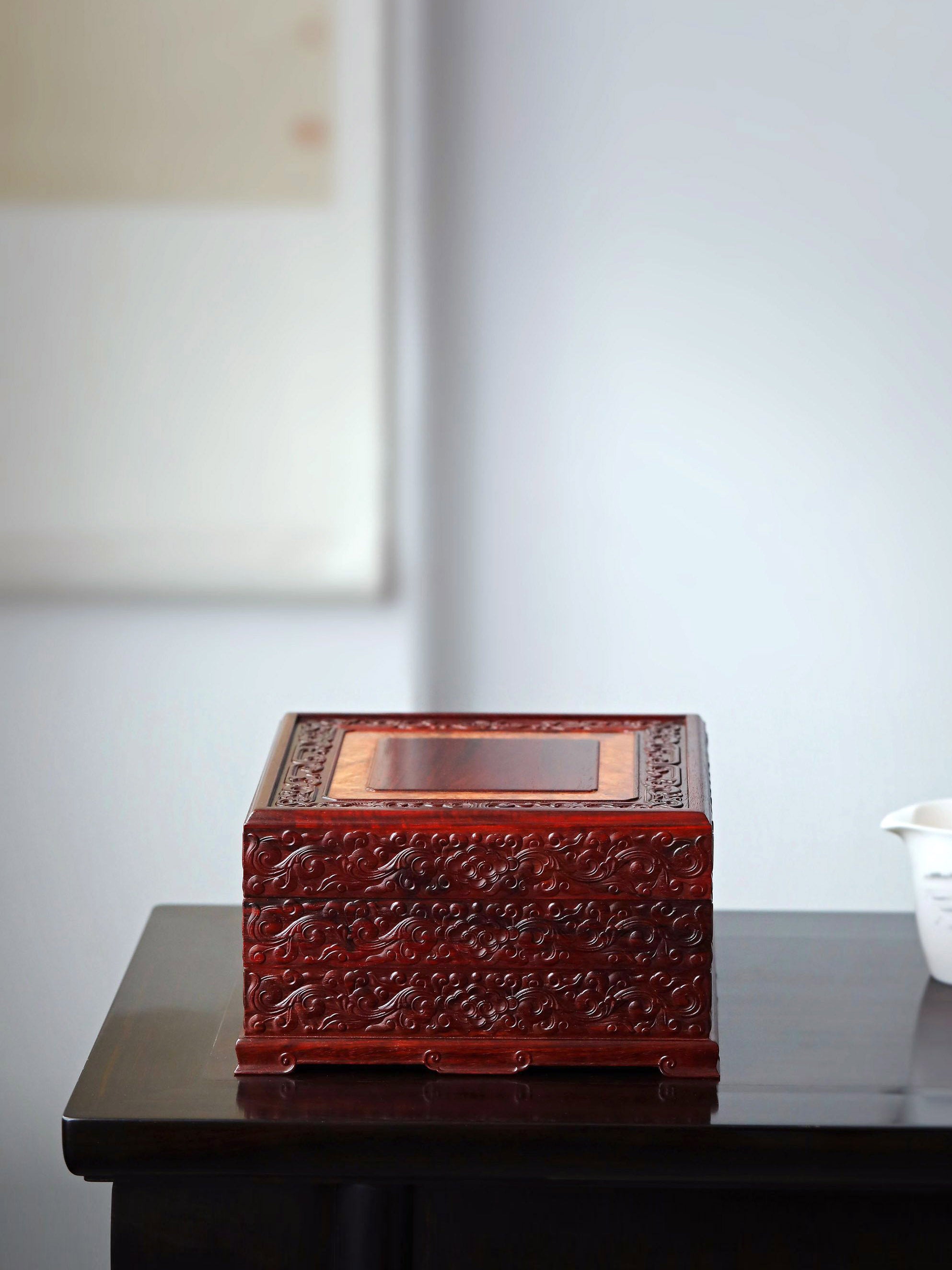 Small-leaf sandalwood tea box with auspicious cloud and scroll patterns, three-tiered lid and four corners.