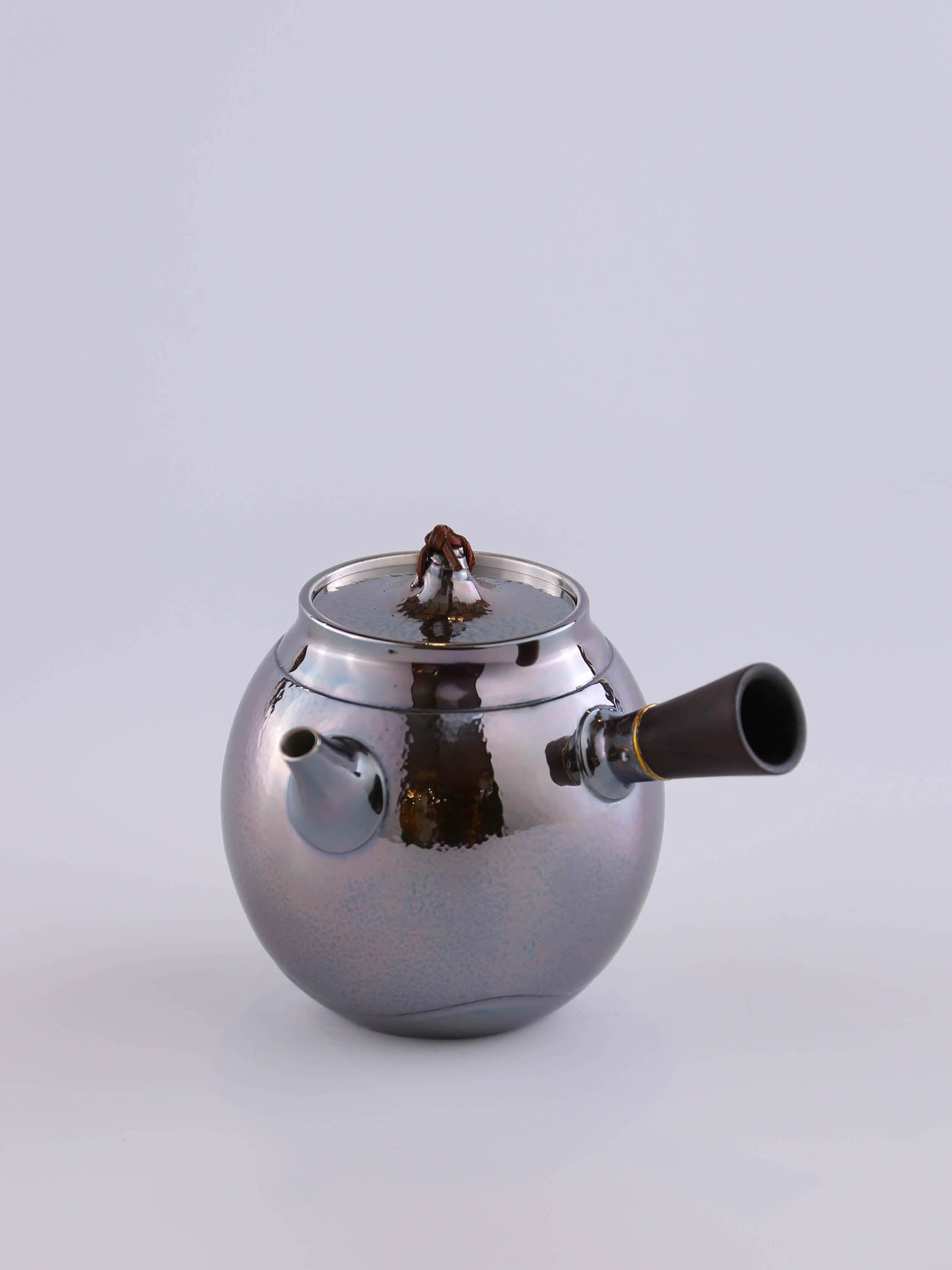 Hong Jike, an inheritor of the intangible cultural heritage, makes a lacquered, side-handled, pure silver teapot.