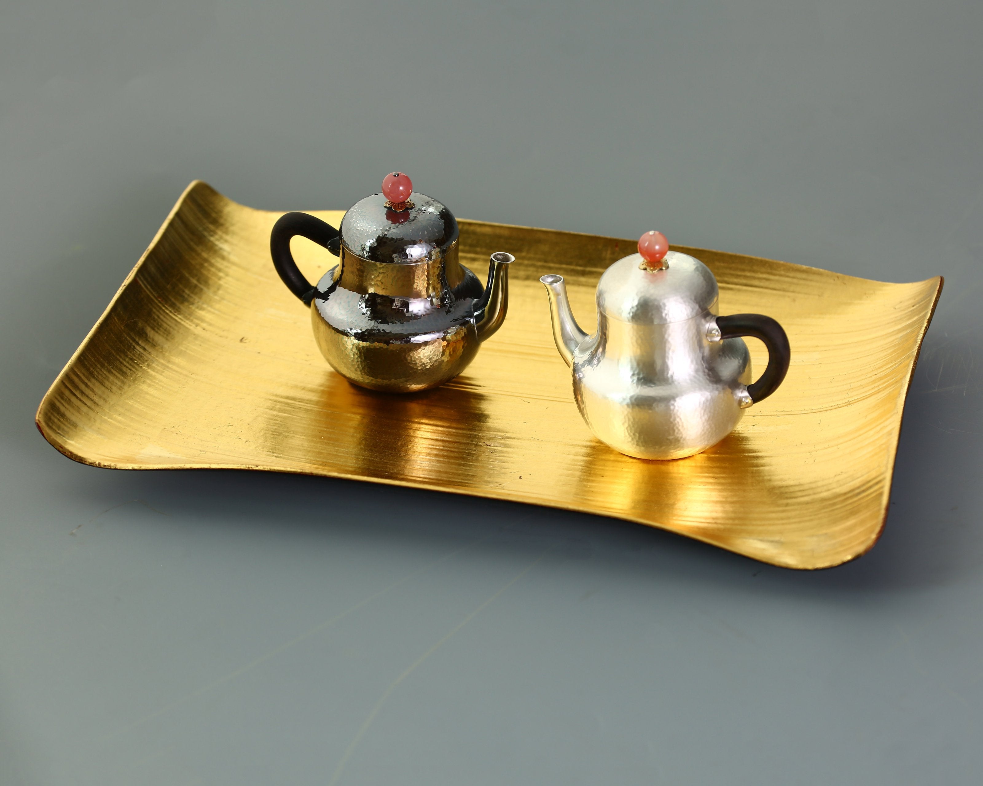 A pair of red-topped Siting sterling silver teapots