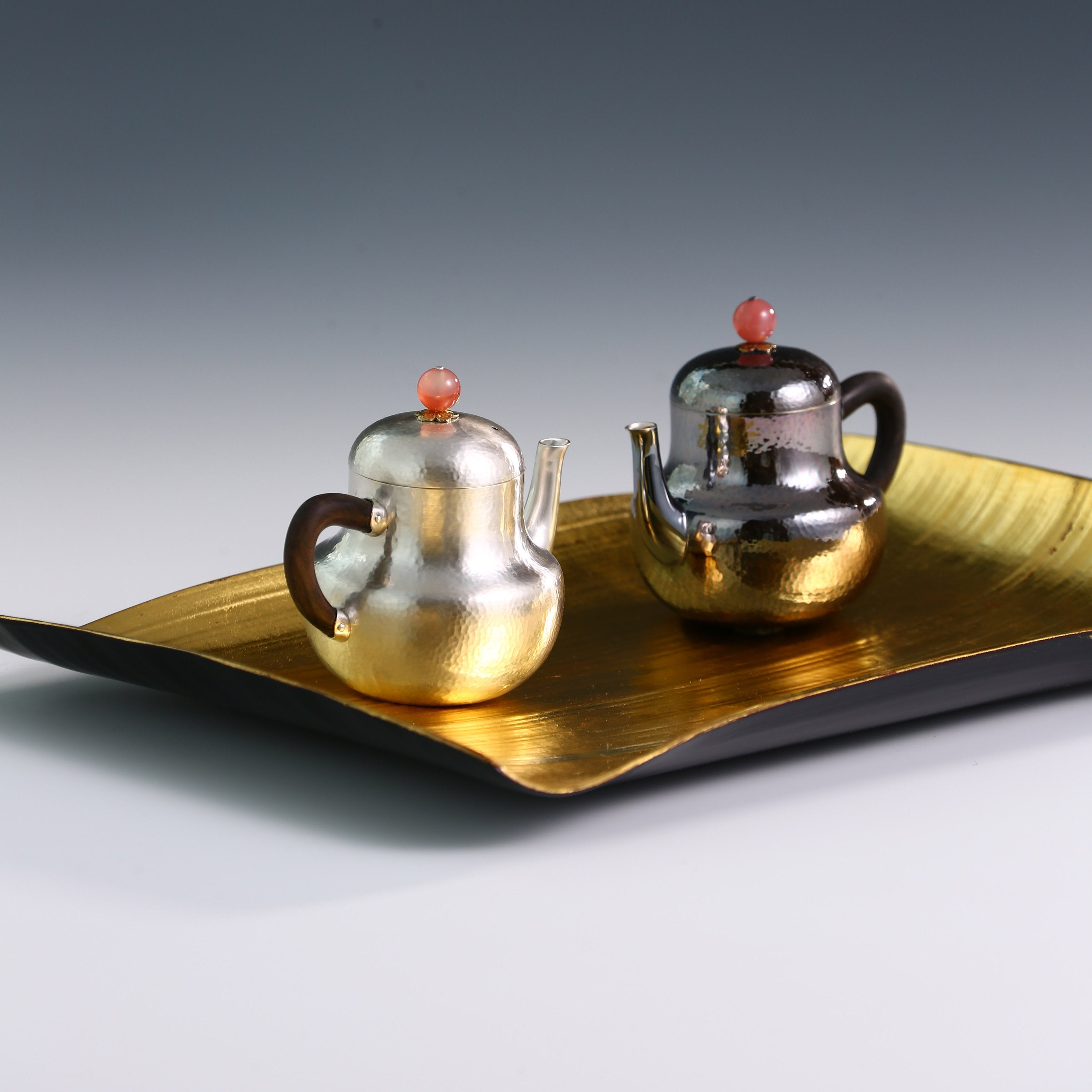 A pair of red-topped Siting sterling silver teapots