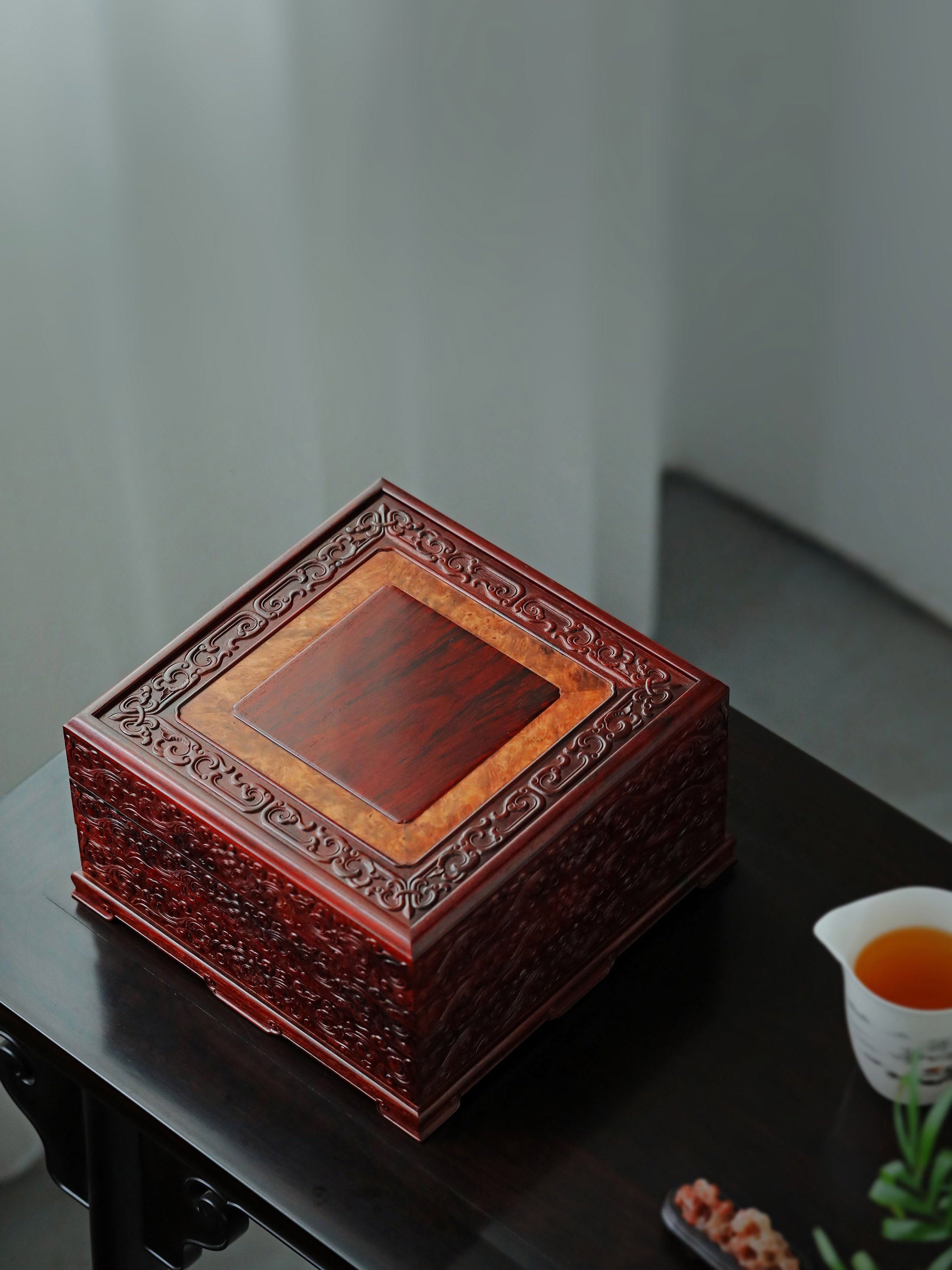 Small-leaf sandalwood tea box with auspicious cloud and scroll patterns, three-tiered lid and four corners.