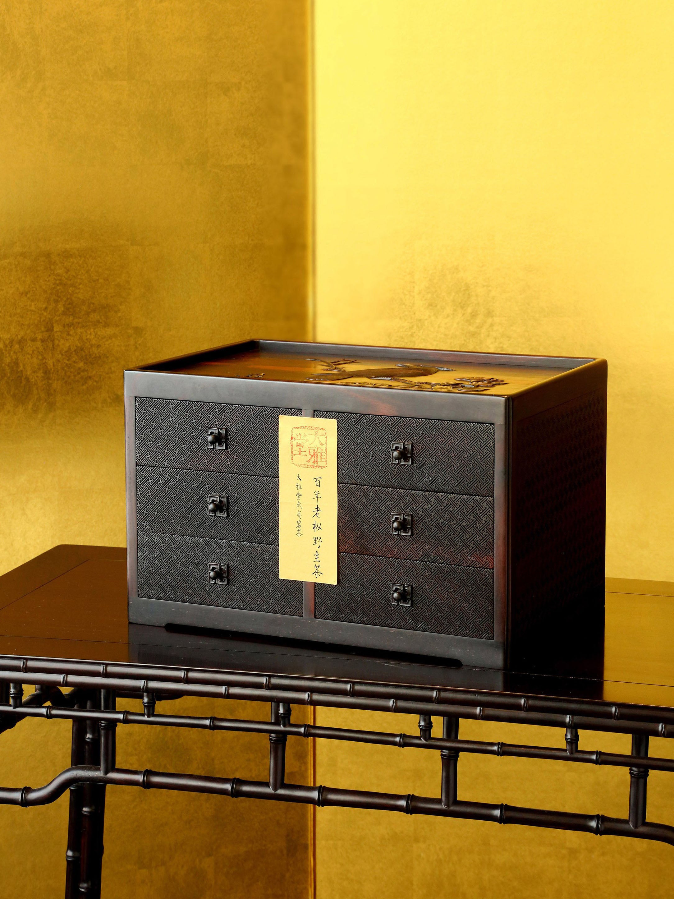 A six-drawer tea box carved with flowers, birds, and swastika patterns on large-leaf sandalwood.
