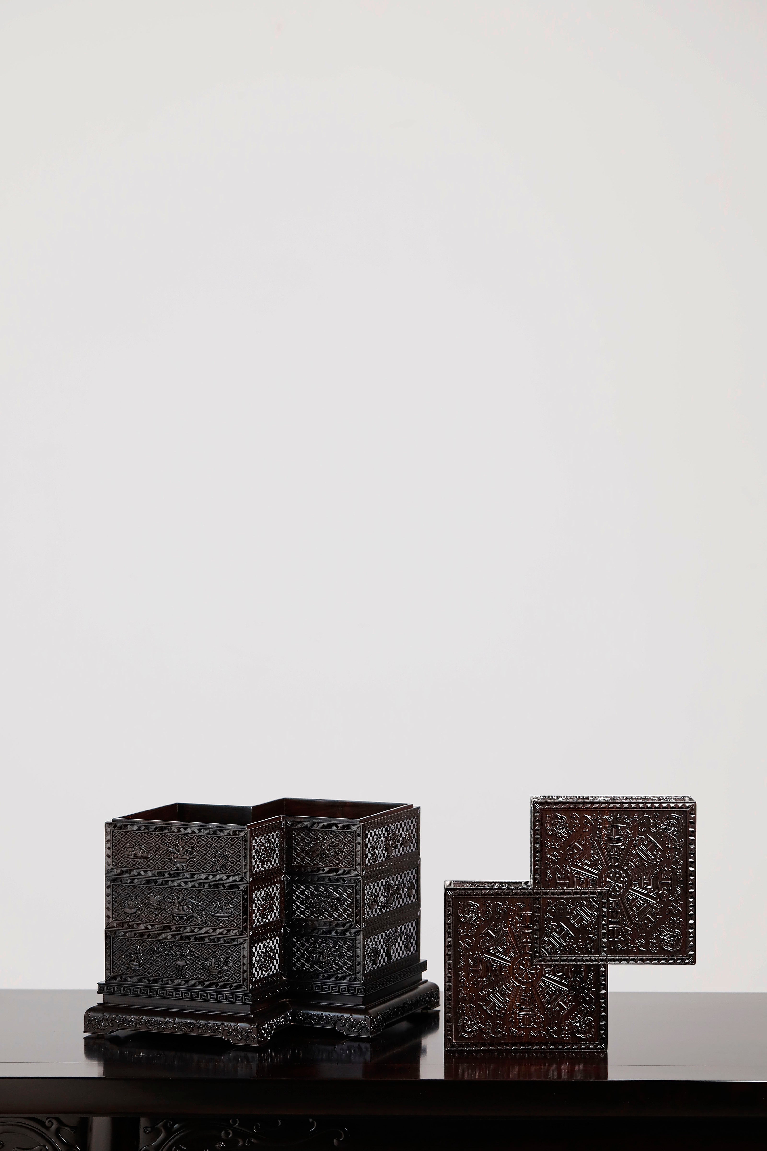 Four-tiered box in the shape of a square knot with full carvings of floral and dragon patterns.