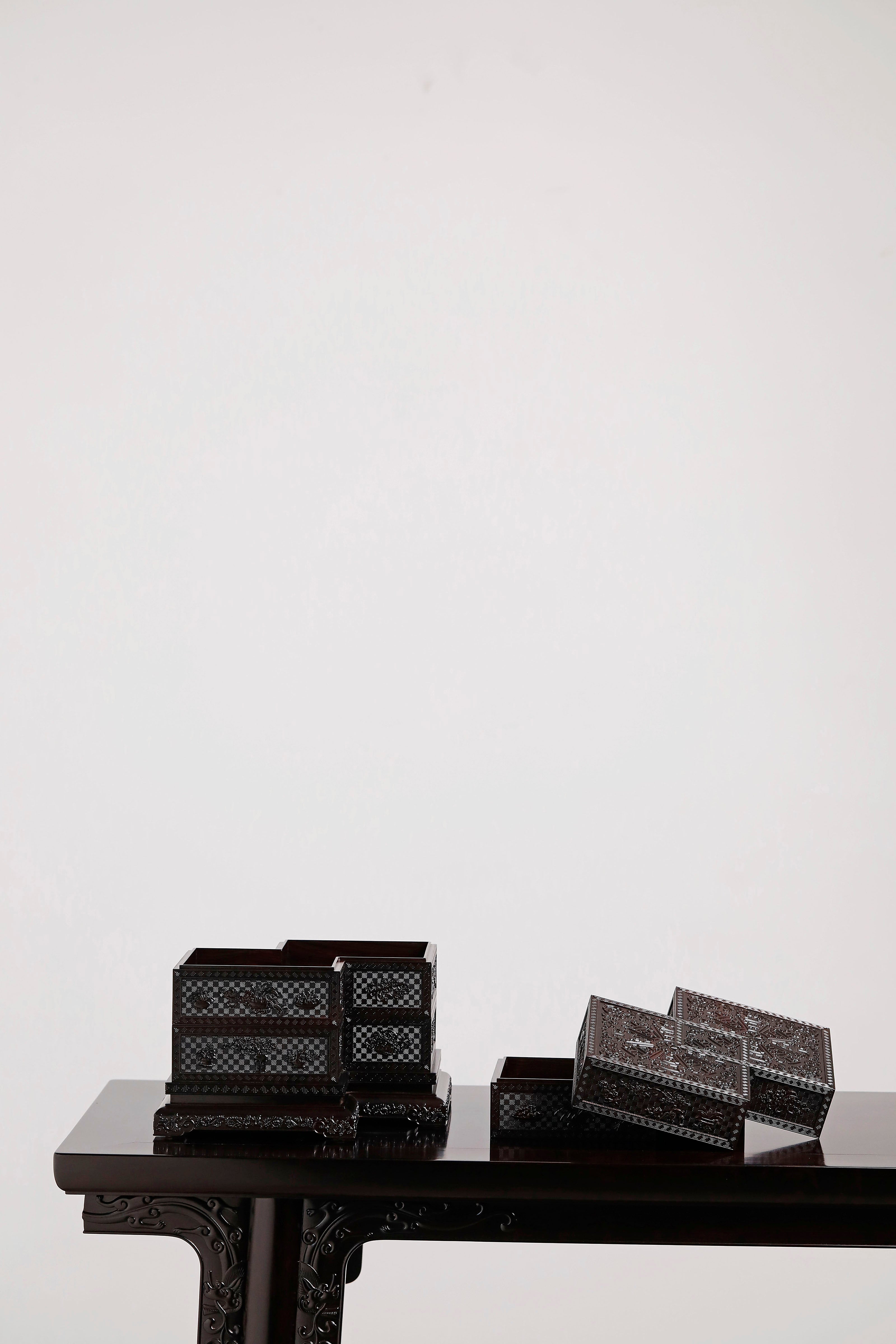 Four-tiered box in the shape of a square knot with full carvings of floral and dragon patterns.