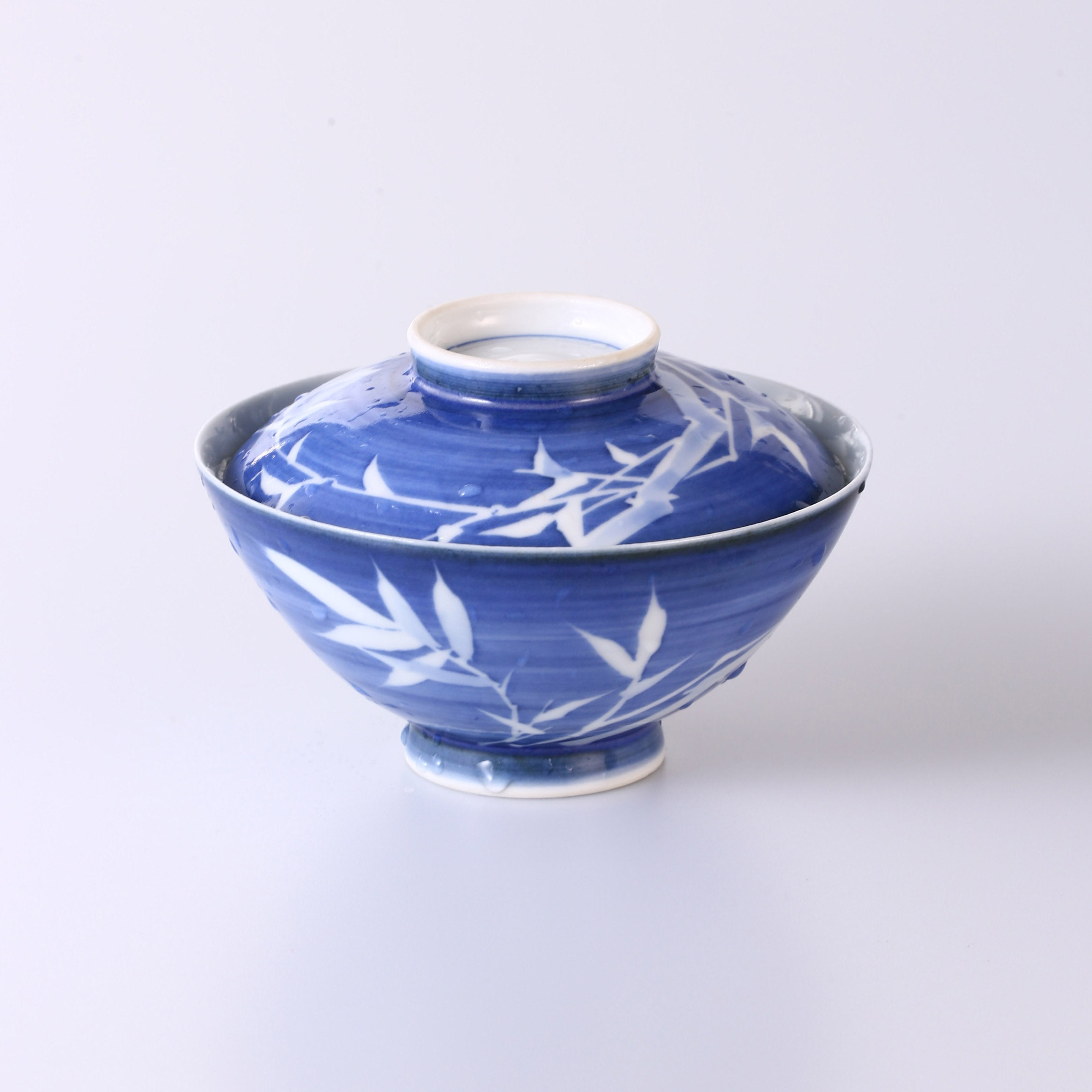 Blue and white porcelain covered bowl with water features, reflecting noble character and integrity.