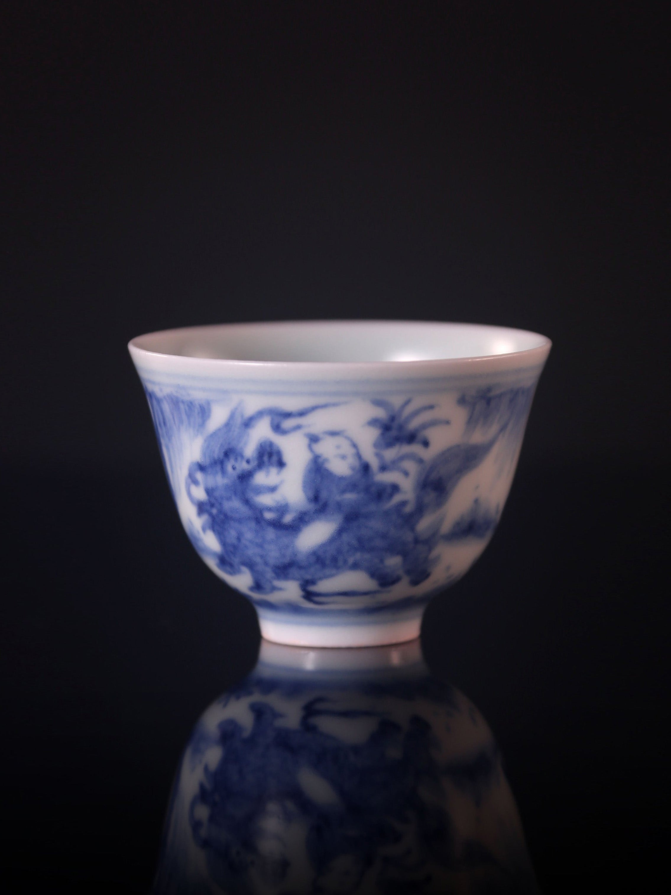 Blue and white porcelain cup with a unicorn and a child