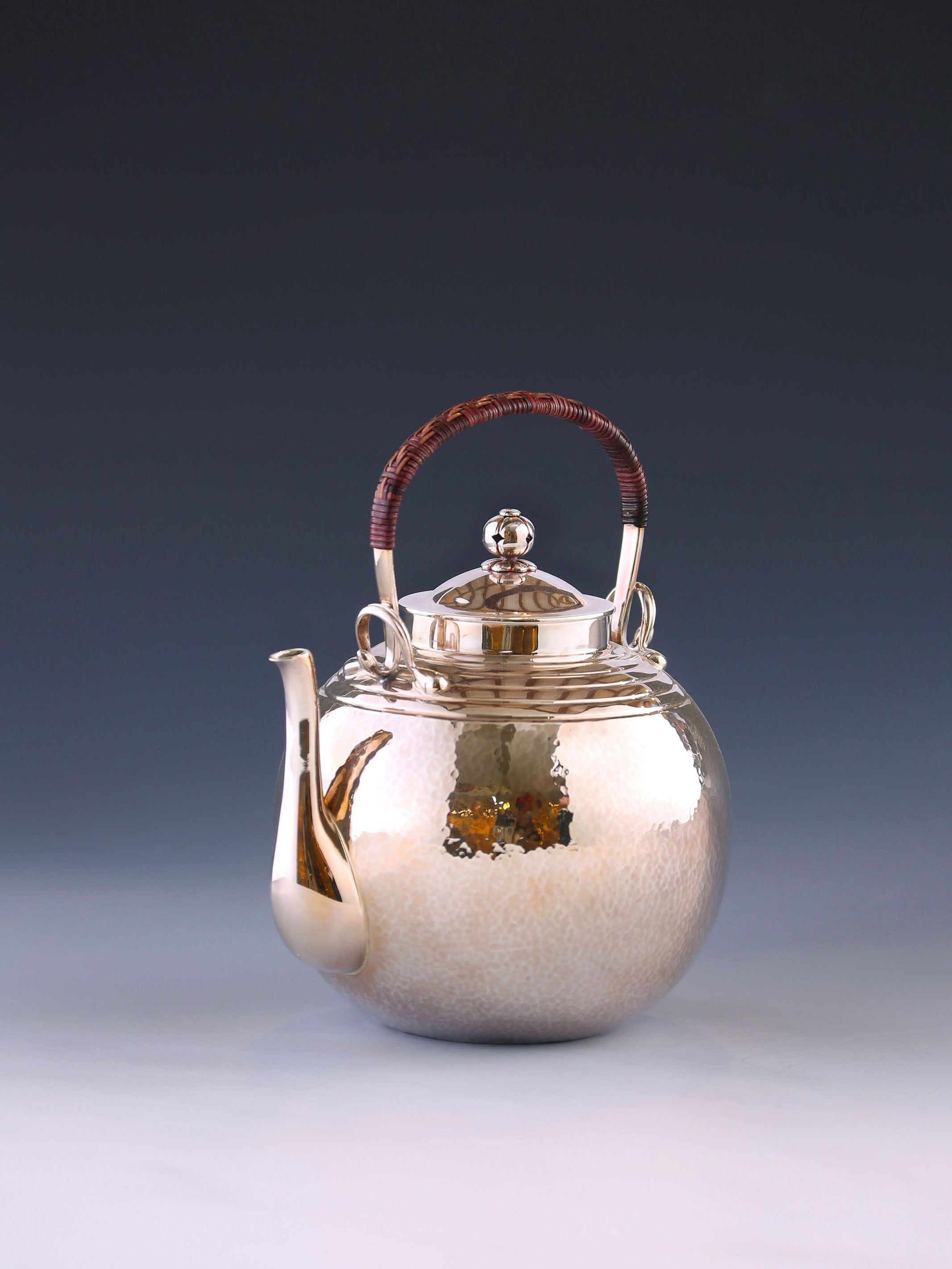 Round-shaped hammered silver teapot