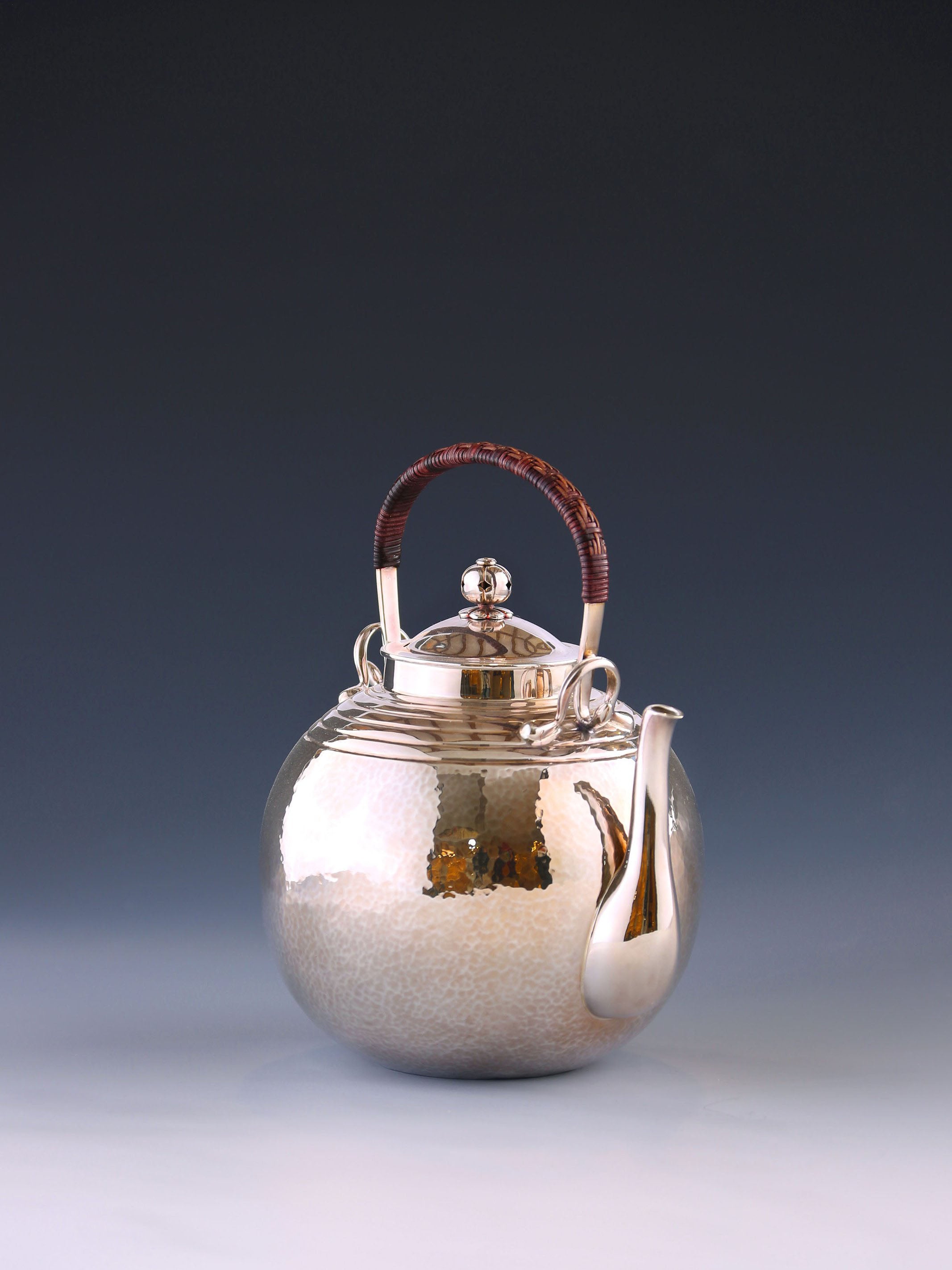 Round-shaped hammered silver teapot