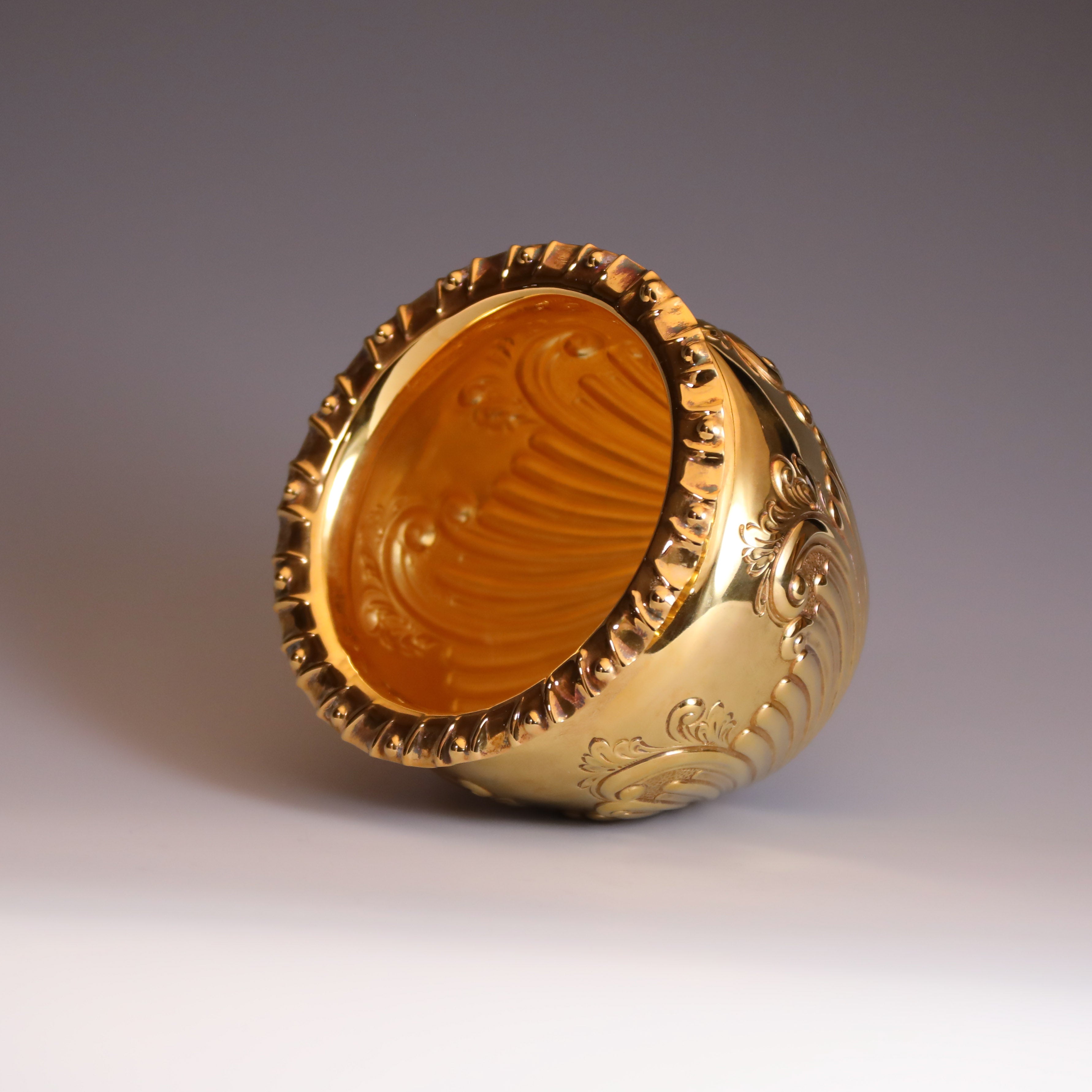 A sterling silver gilt scroll-patterned water dropper from Sheffield, England, between 1904 and 1905.