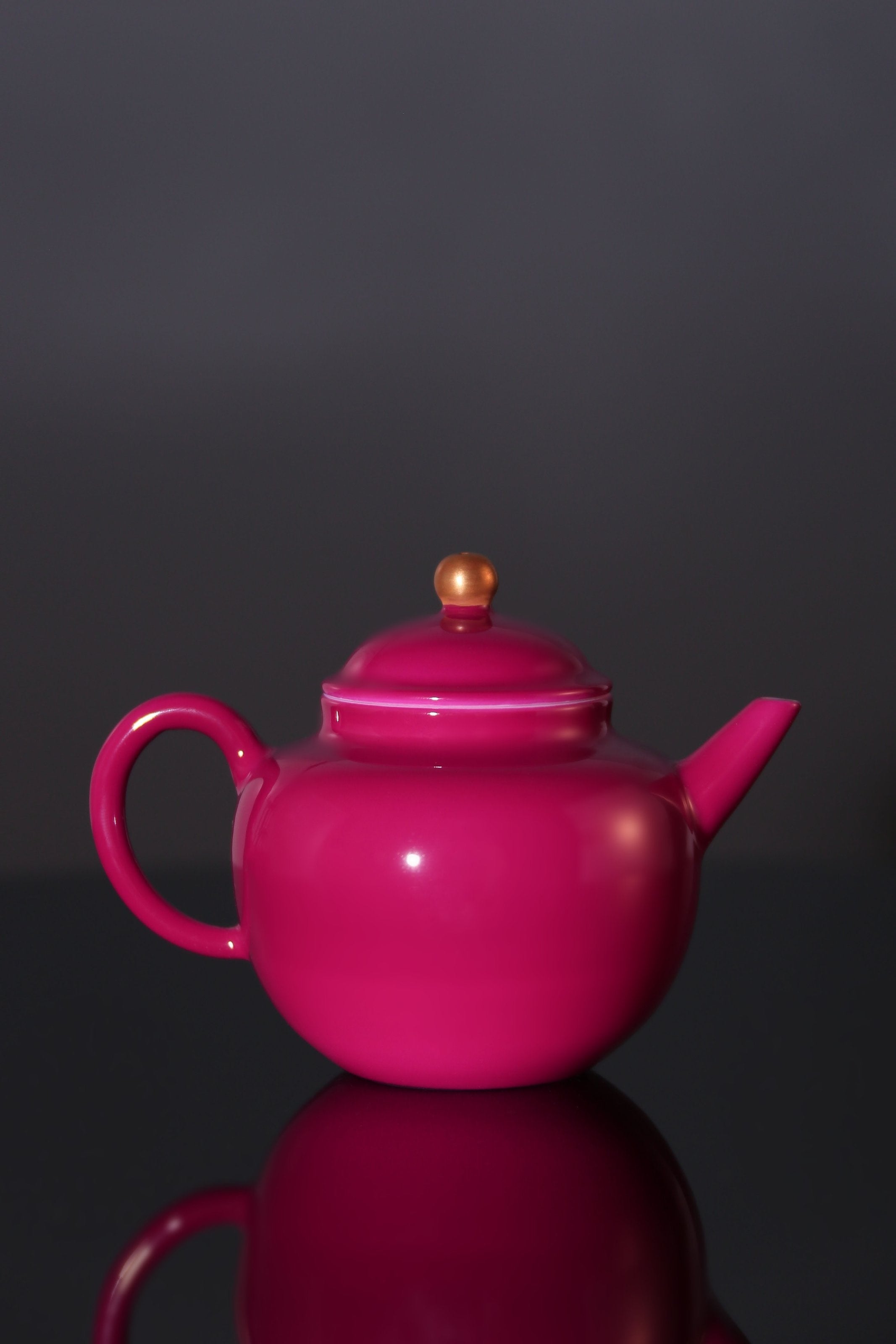 A red-knobbed, gold-decorated teapot
