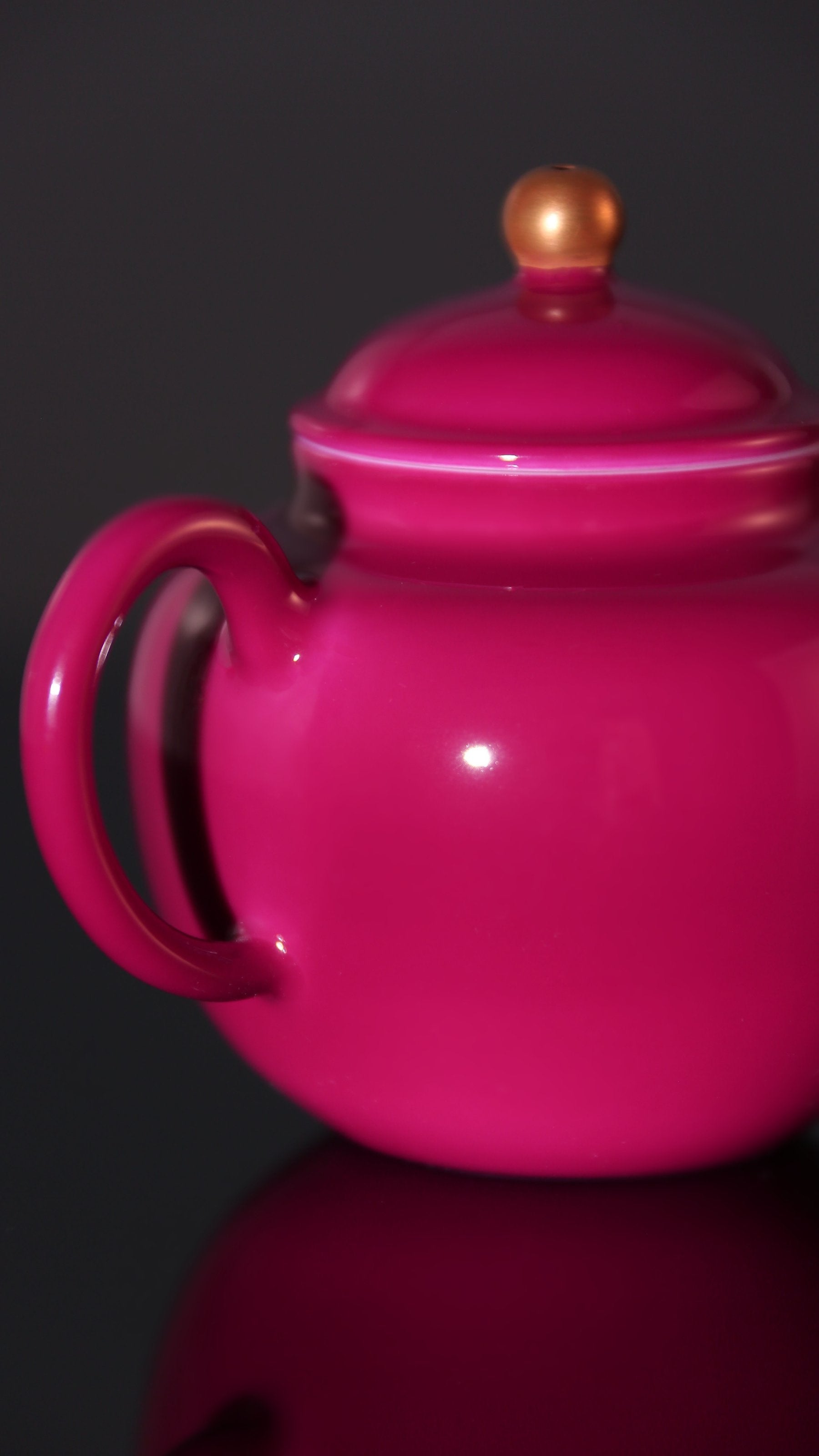 A red-knobbed, gold-decorated teapot